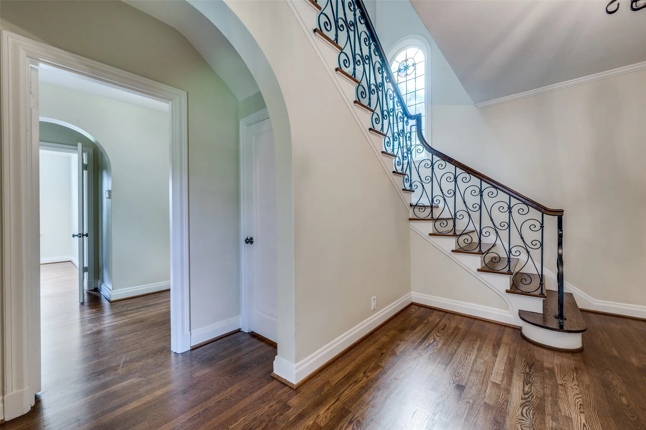 Elegant split staircase with classic archway.