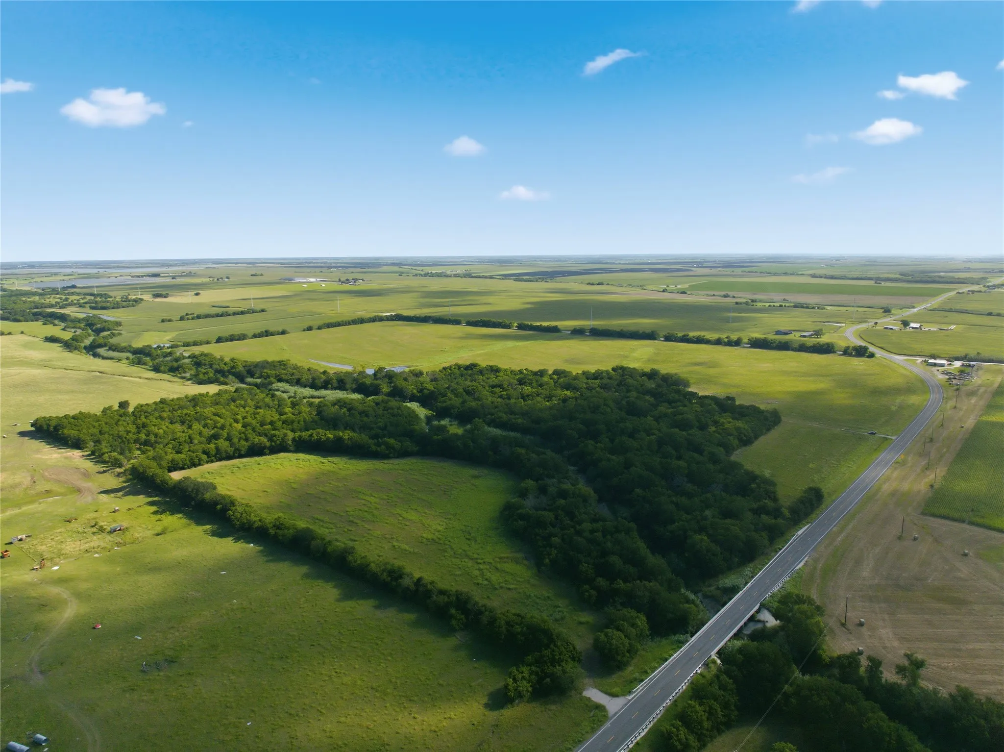 Expansive land parcel featuring a mix of open fields and mature tree lines