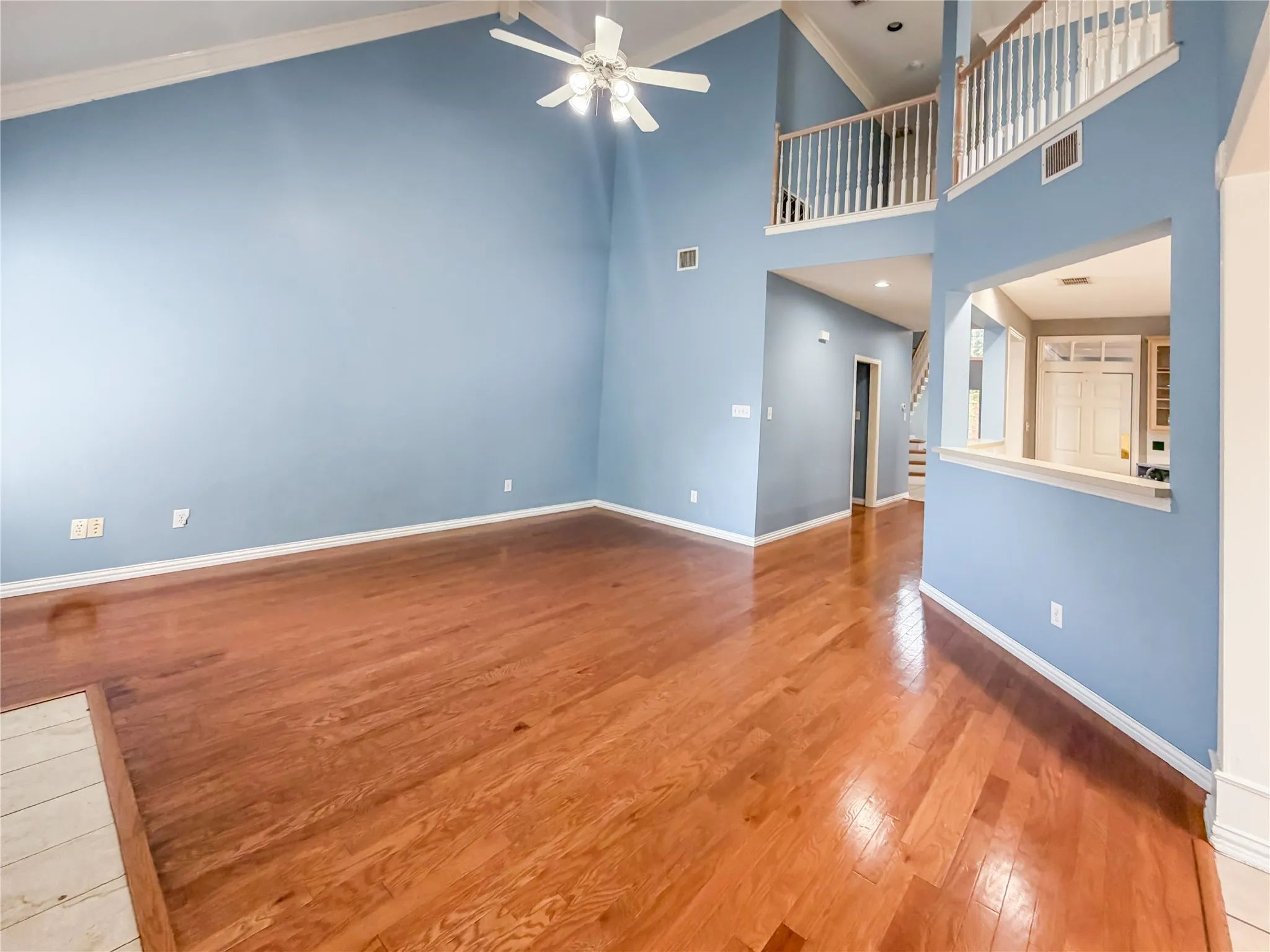 Vaulted ceilings and wood-finish flooring define this bright living space