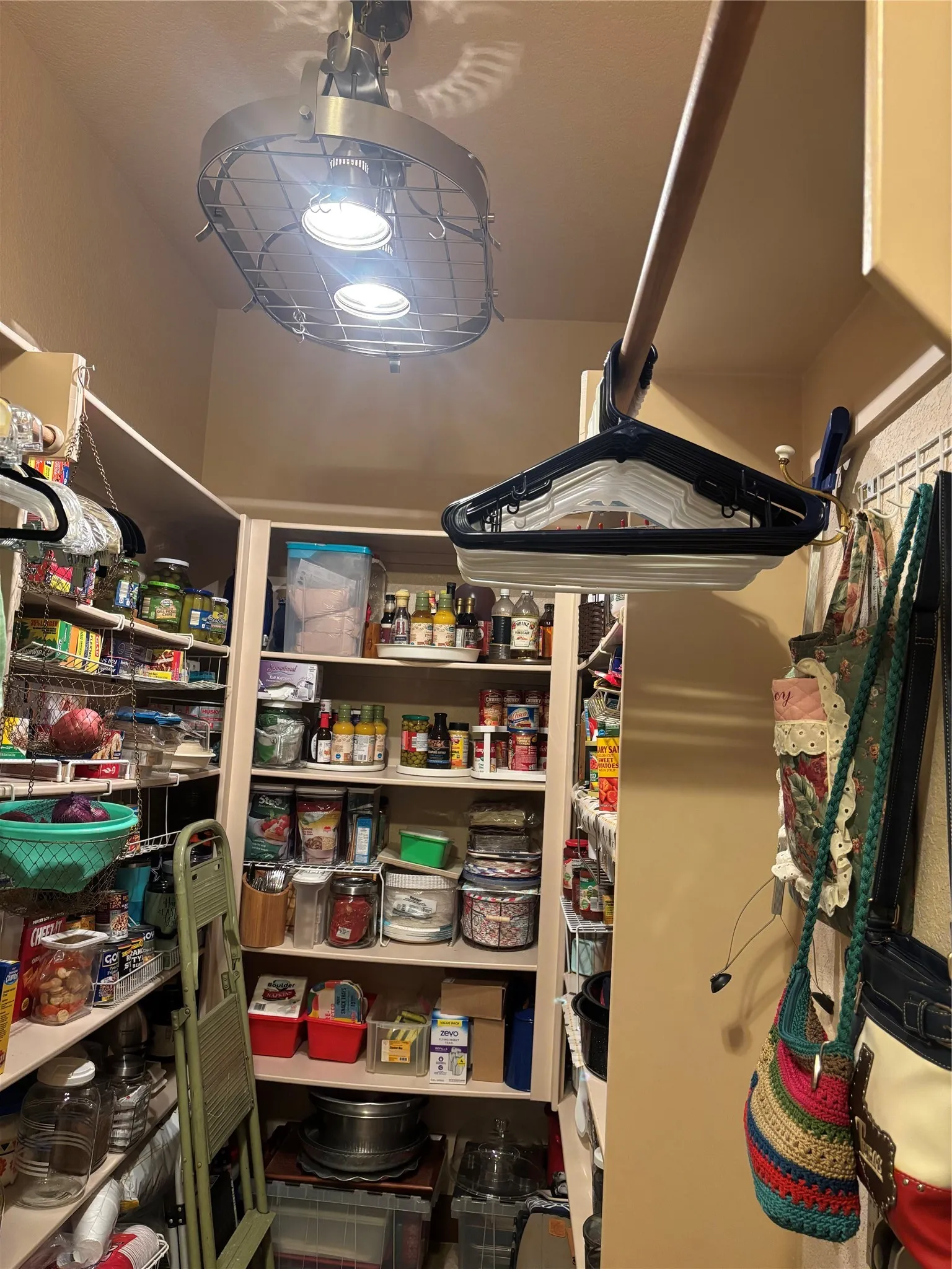 Pantry room featuring extensive shelving, built-in storage, and overhead lighting