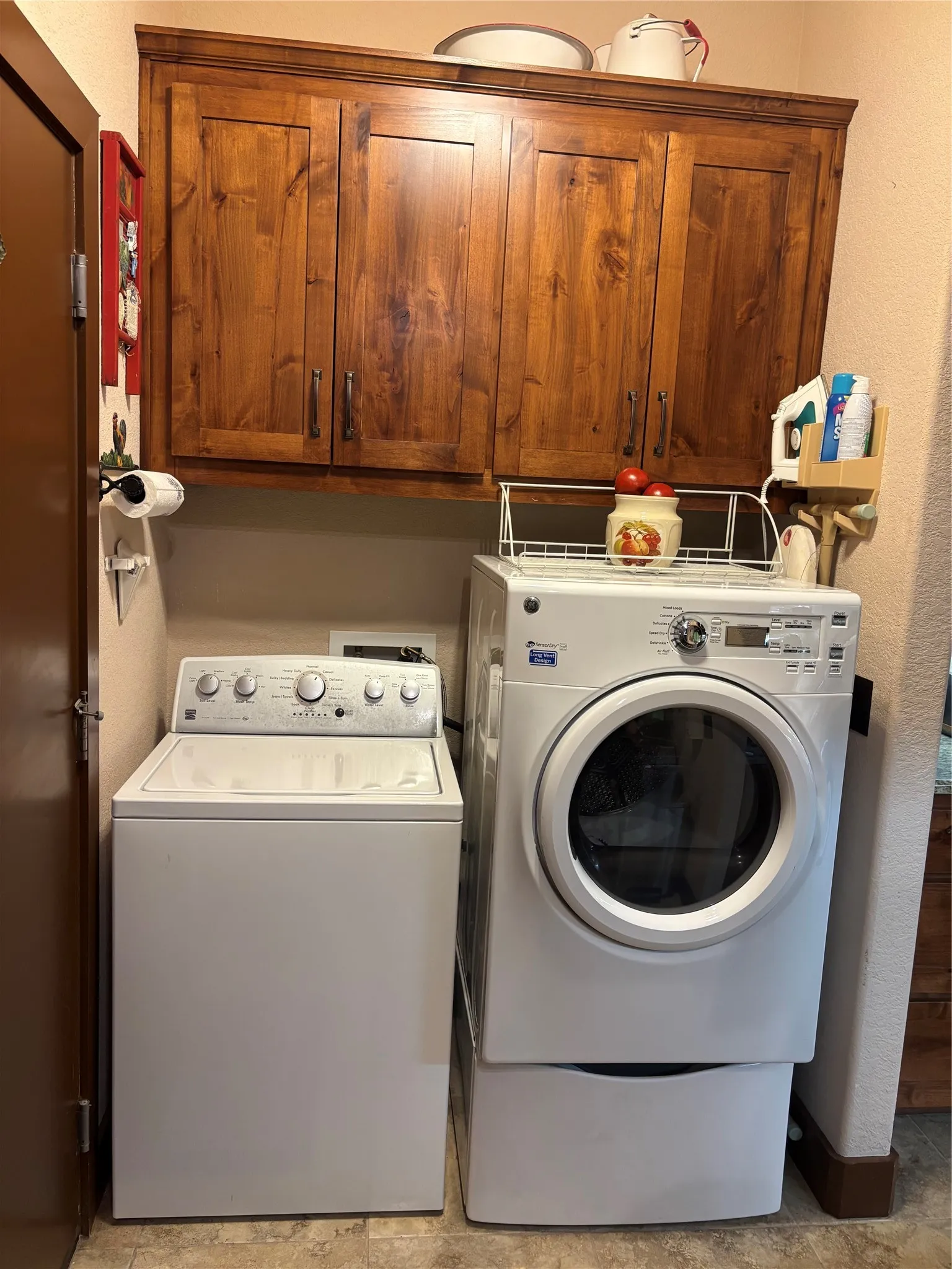 Dedicated laundry area featuring wood-finish cabinetry providing ample storage