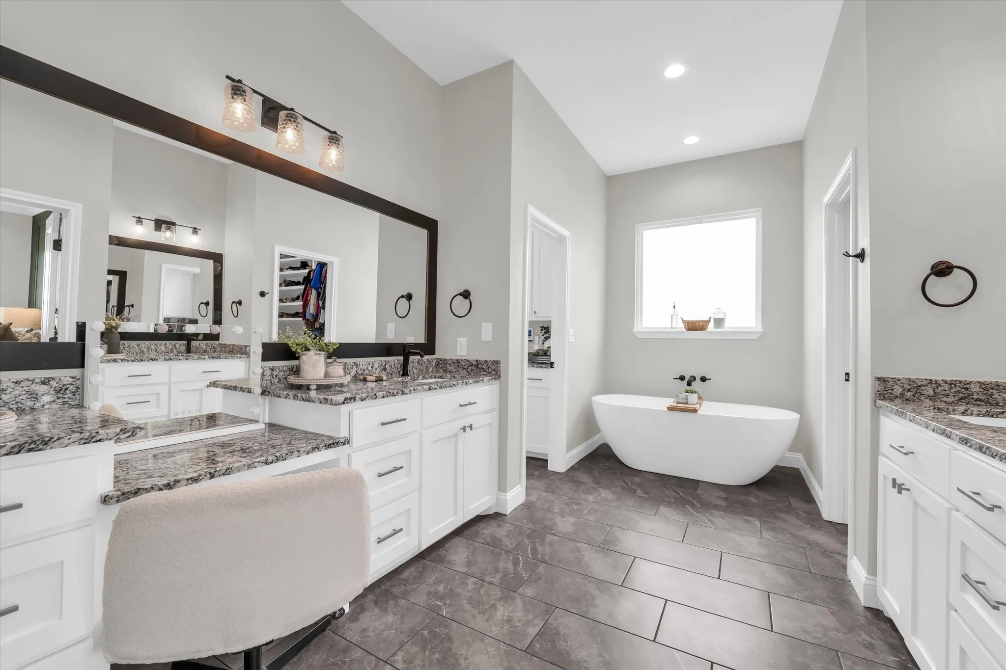 primary bathroom with soaking tub, separate vanities, separate tiled shower