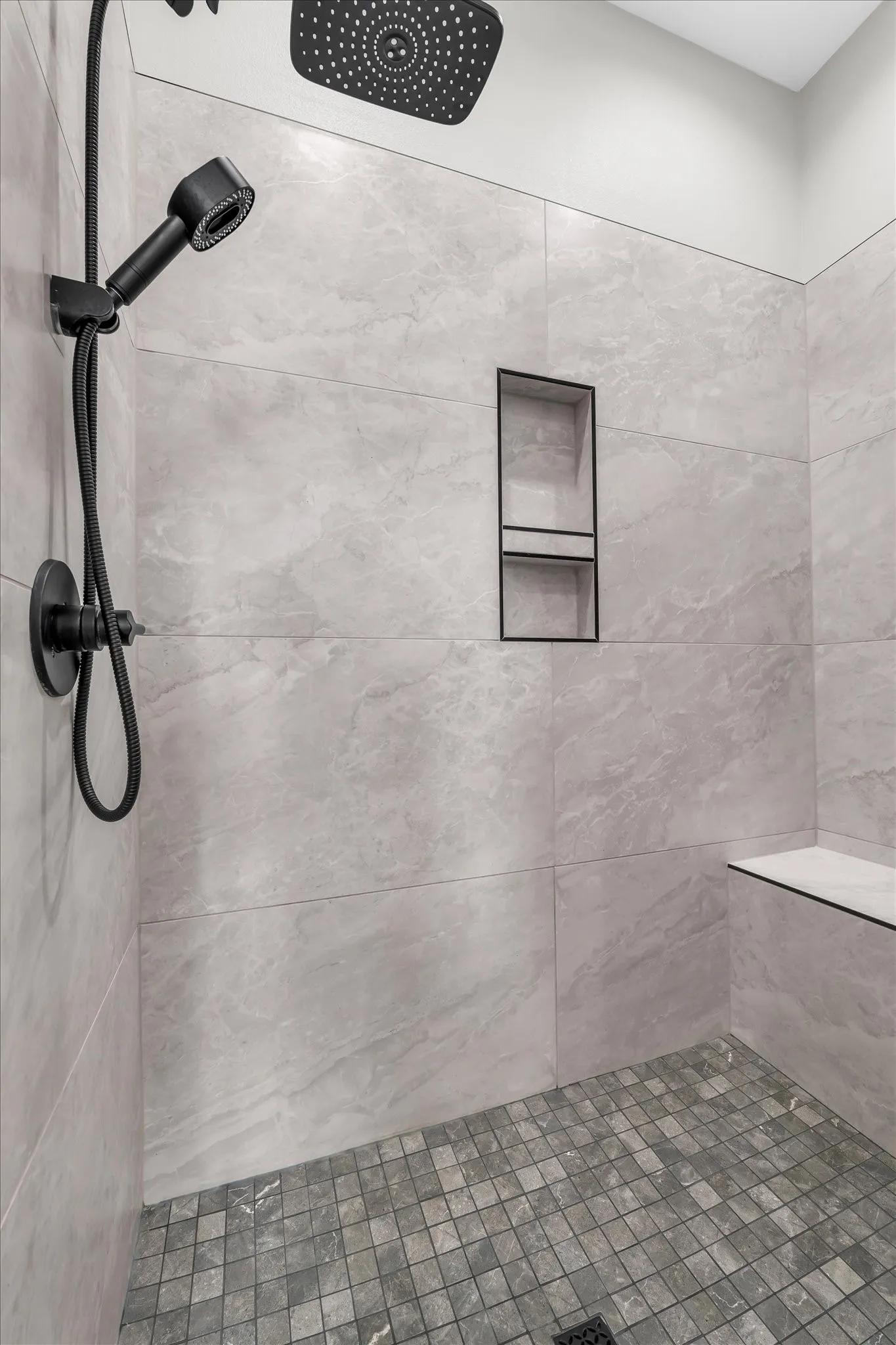 separate tiled shower with bench in primary bathroom