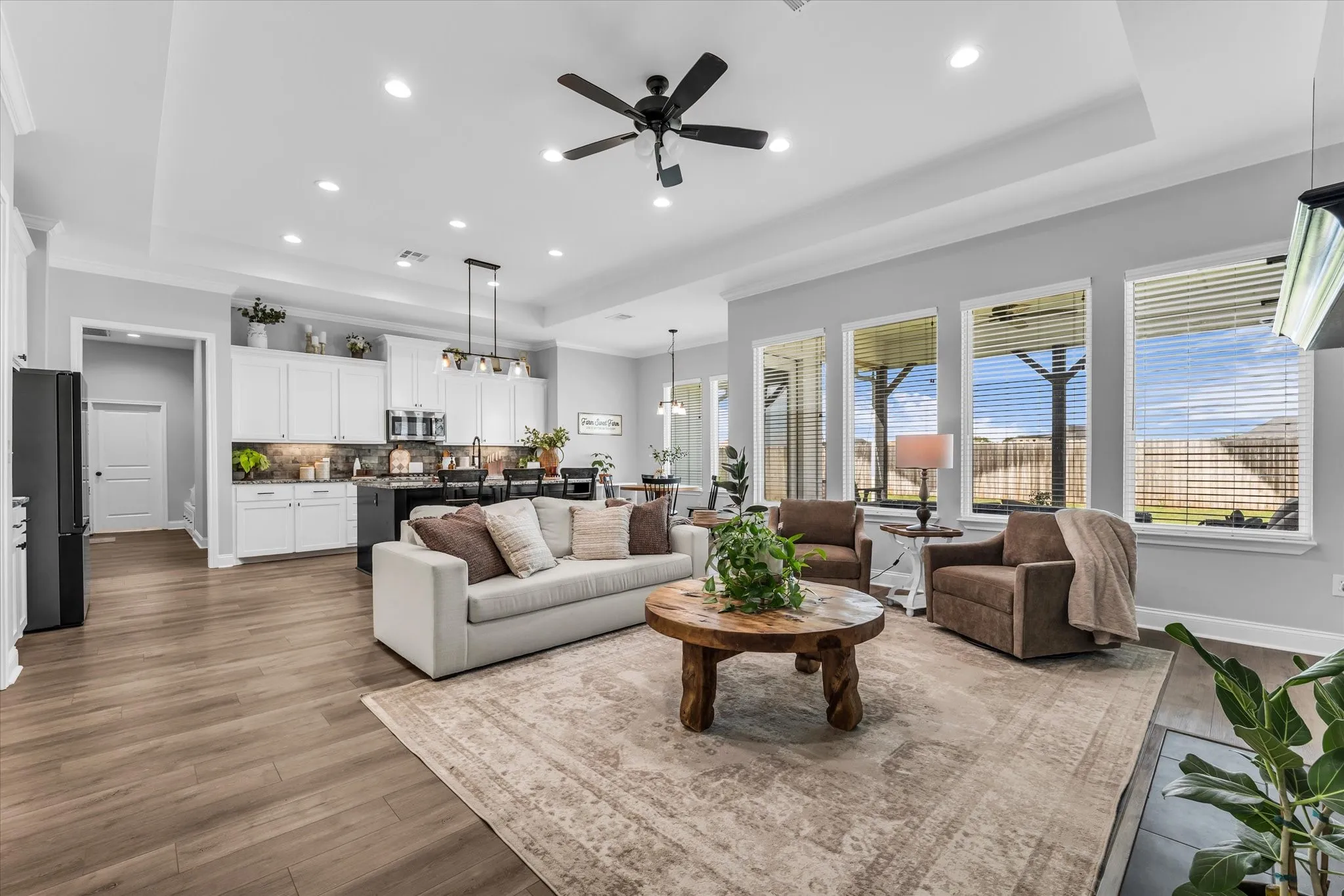 living room with built ins and open layout to kitchen and view of covered back porch and backyard