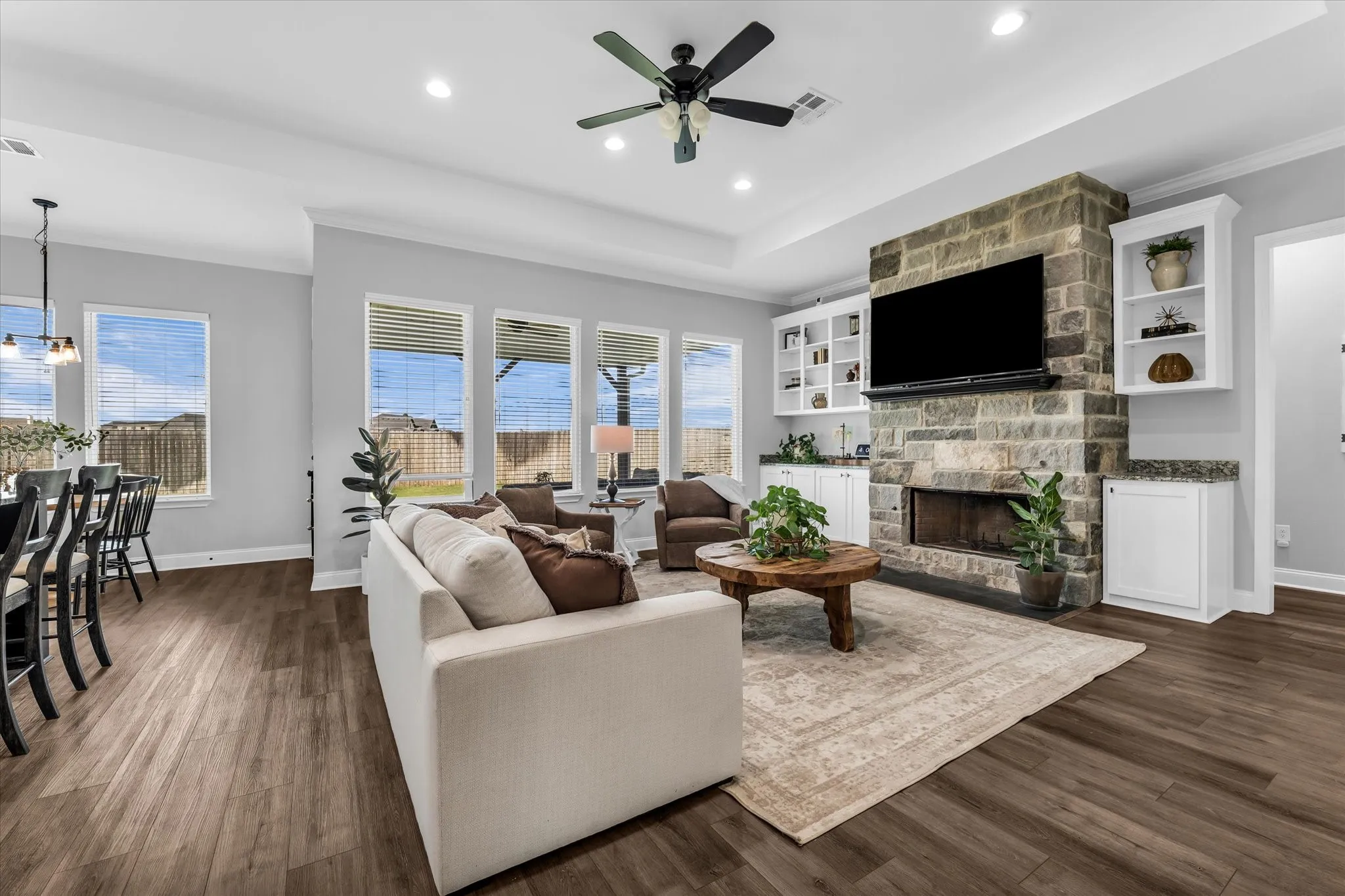 living room with large windows to covered back porch and backyard; open to kitchen and eat in kitchen
