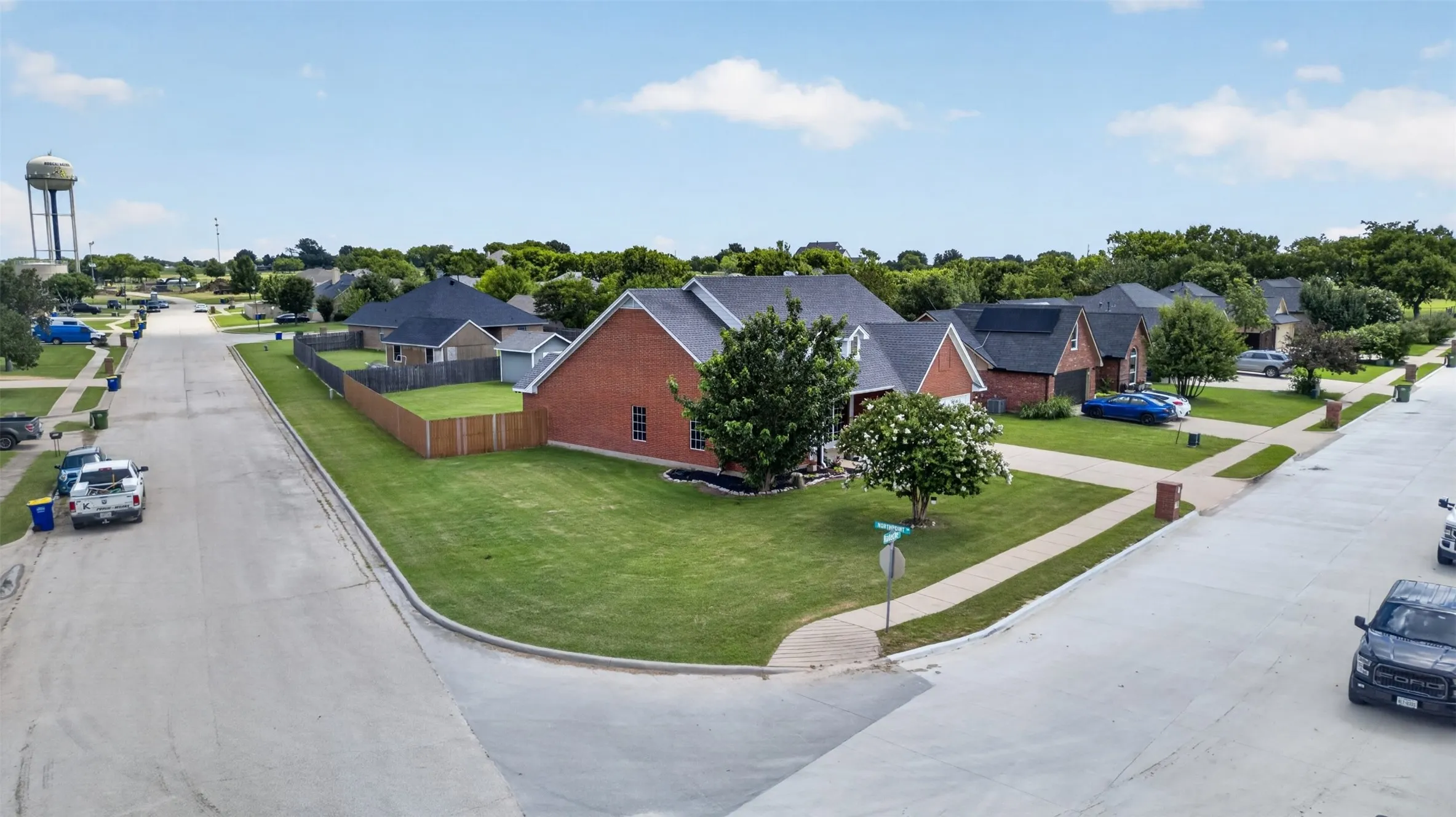 Corner lot property featuring a brick exterior and an attached garage