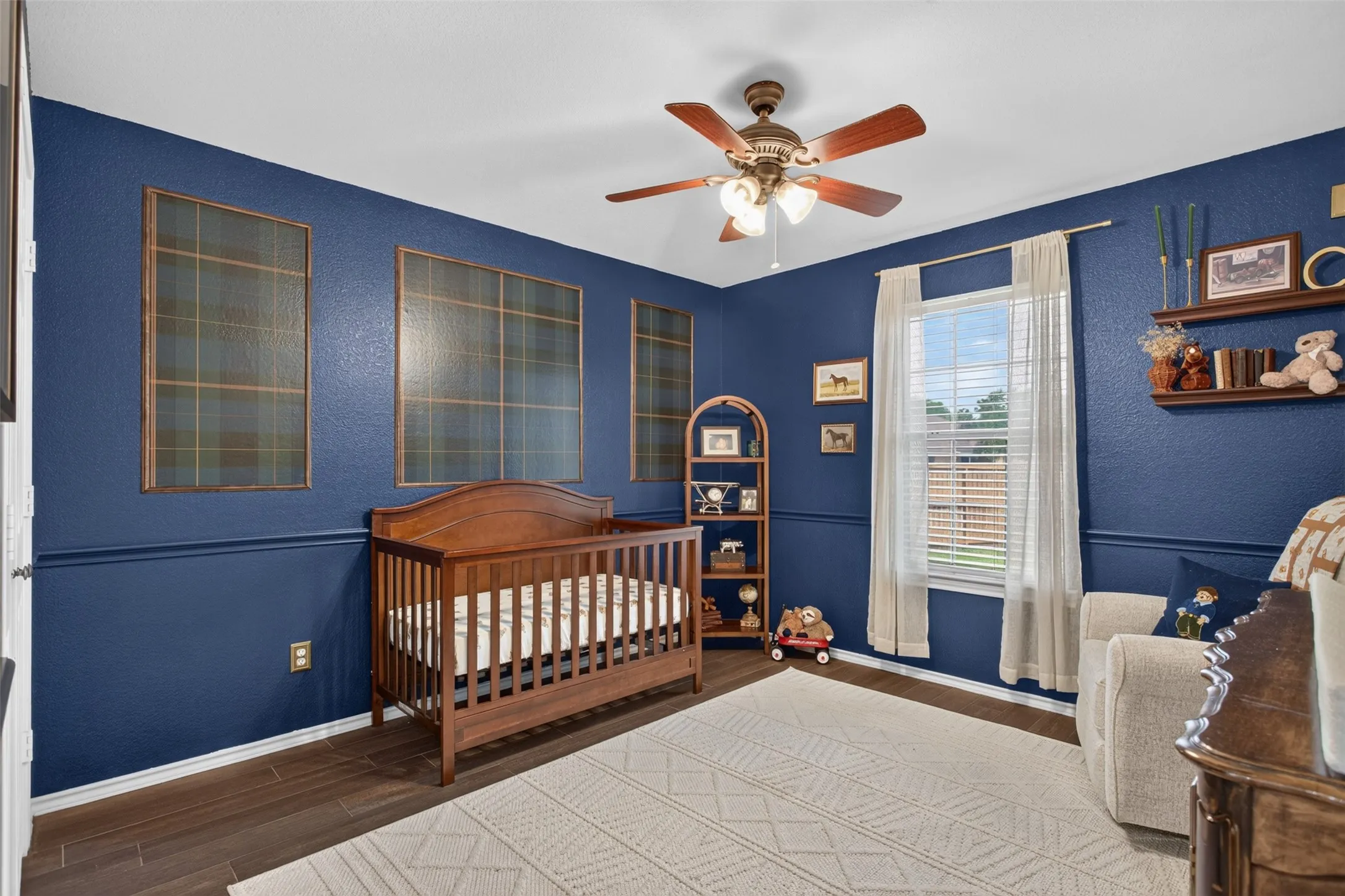 Room with deep blue walls and wood-finish flooring