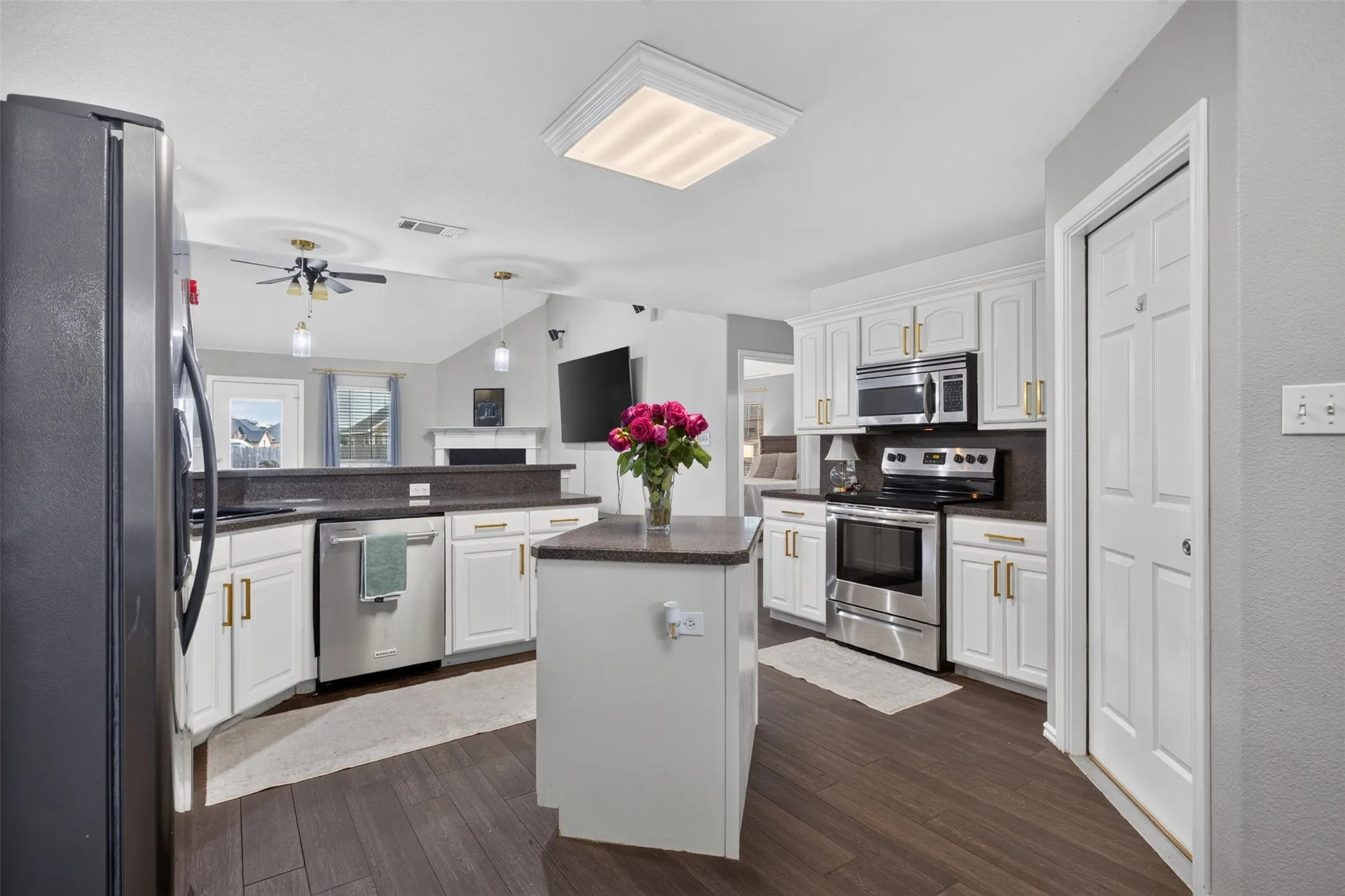 Modern kitchen featuring white cabinetry, dark countertops, and stainless steel appliances