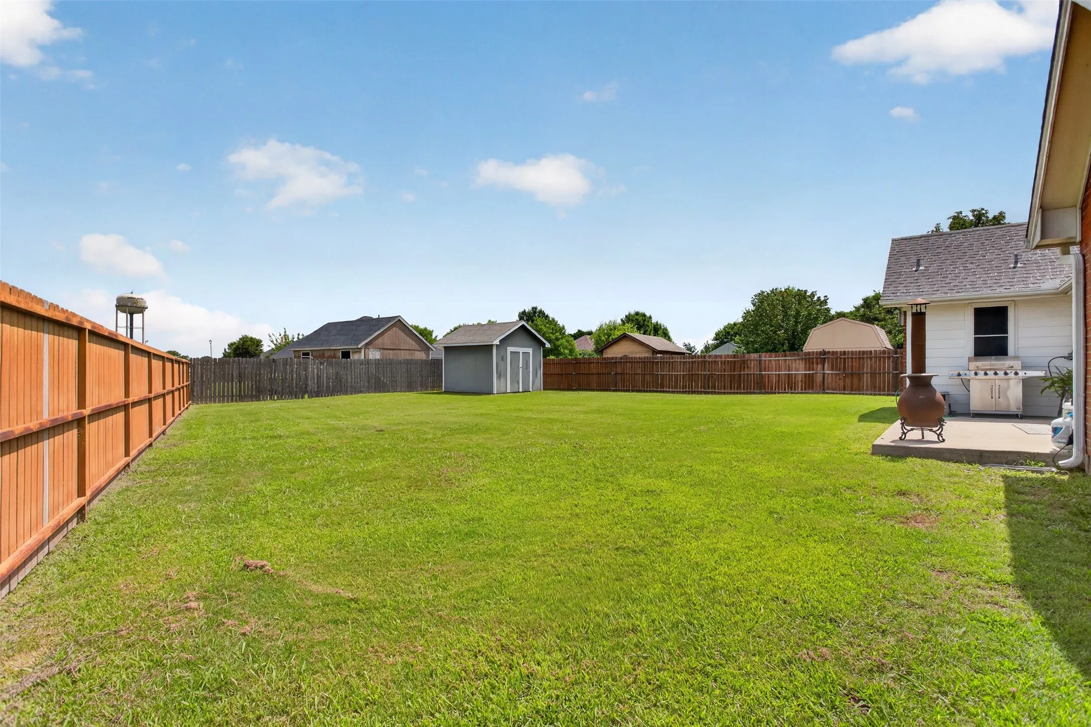 Expansive green lawn with a wood privacy fence
