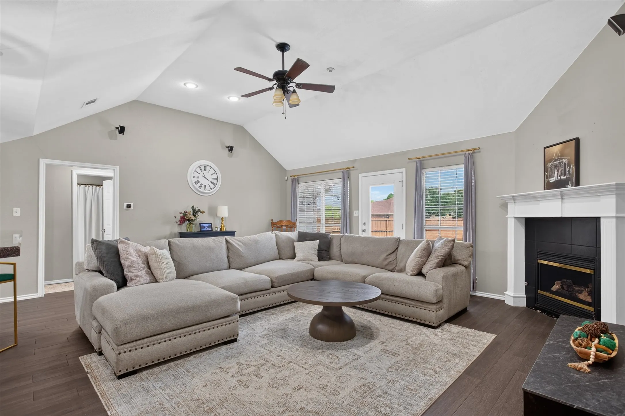 Spacious living area featuring vaulted ceilings, dark wood-finish flooring, and recessed lighting