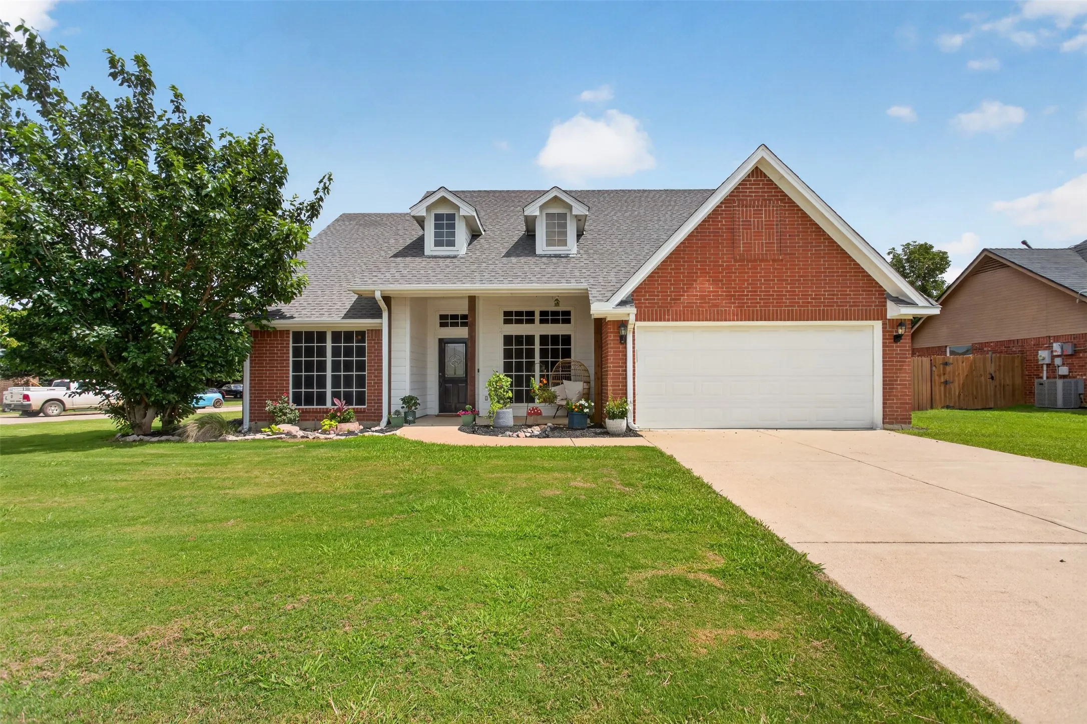 Brick exterior with white trim, a gabled roof, and dormer windows