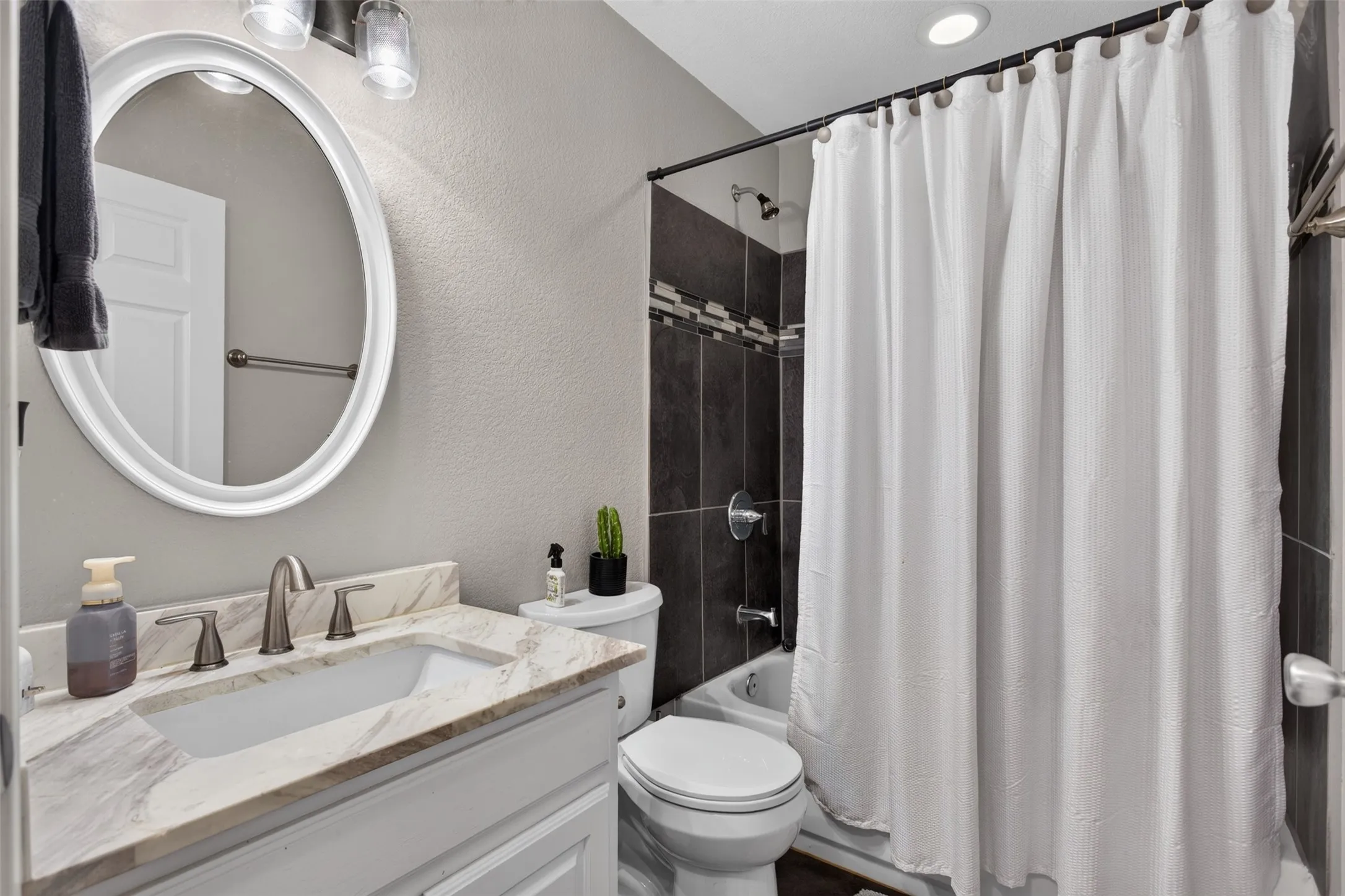 Bathroom vanity featuring a rectangular undermount sink, dual-handle faucet, and patterned countertop