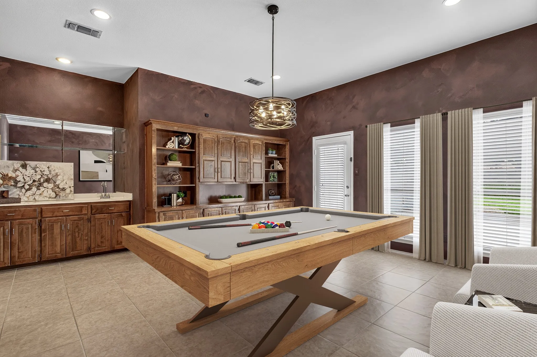 Two versatile flex spaces offer endless possibilities for a home office, hobby room, media room, game room, exercise space or additional living- one features extensive wall shelving ideal for an office, while the other is complete with built-ins & a wet bar, creating the perfect setting for impressive entertaining. The furniture and decor in this photo has been virtually staged, not altering the room.