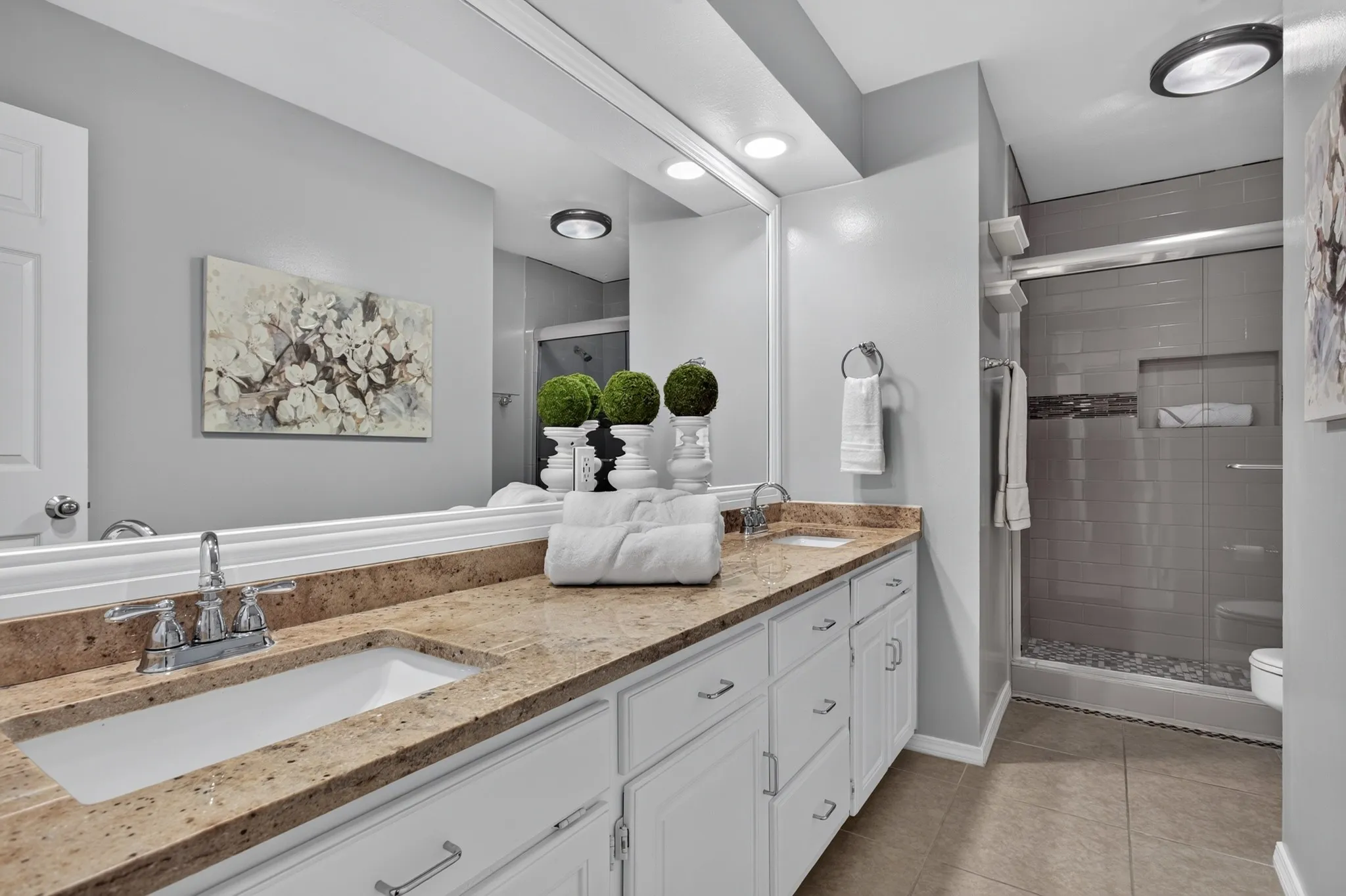 Two additional beds share an updated bath with granite countertops, white cabinetry & a seamless glass shower.