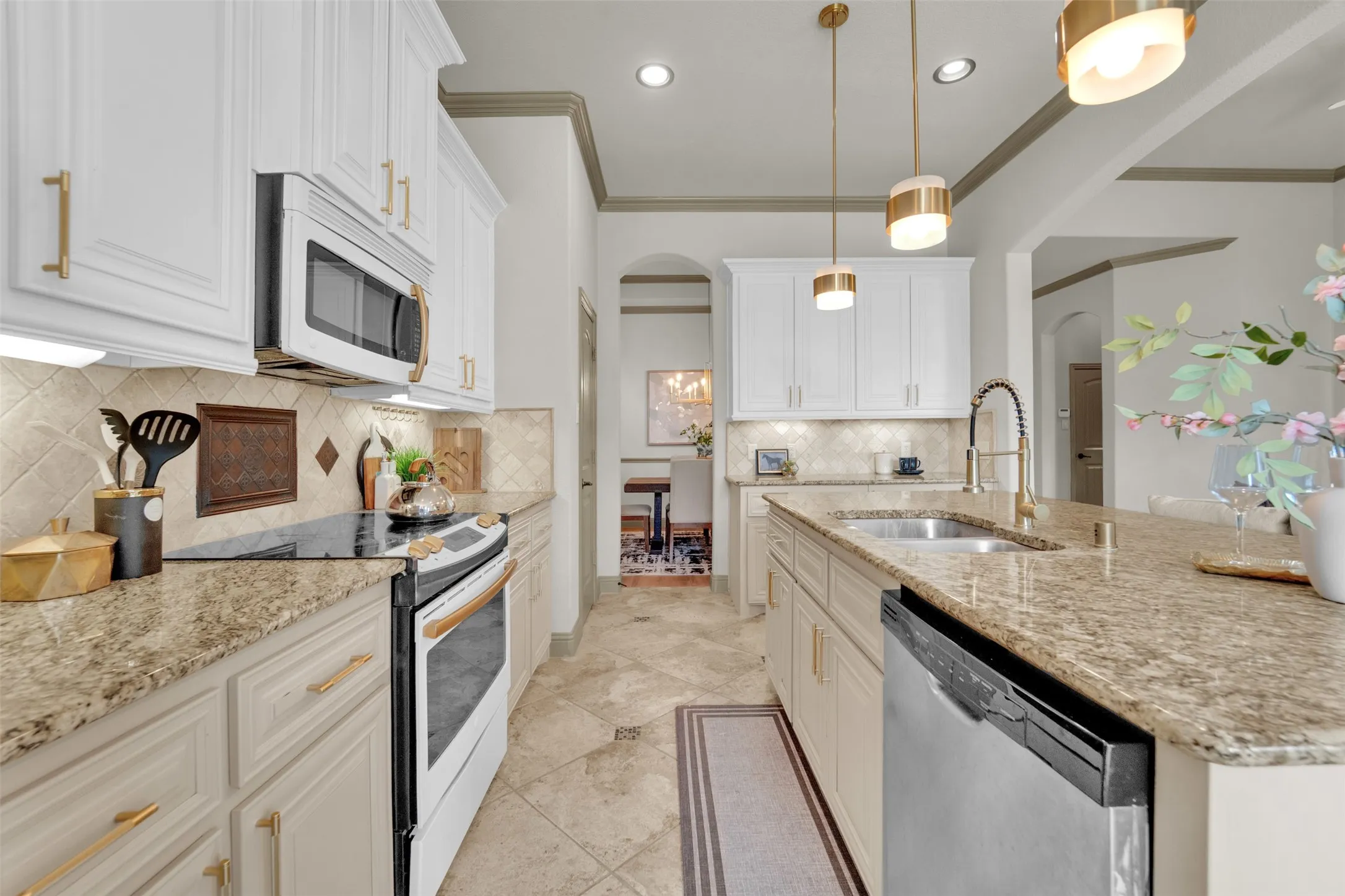 Kitchen featuring white upper cabinetry, light-toned lower cabinetry, and granite countertops