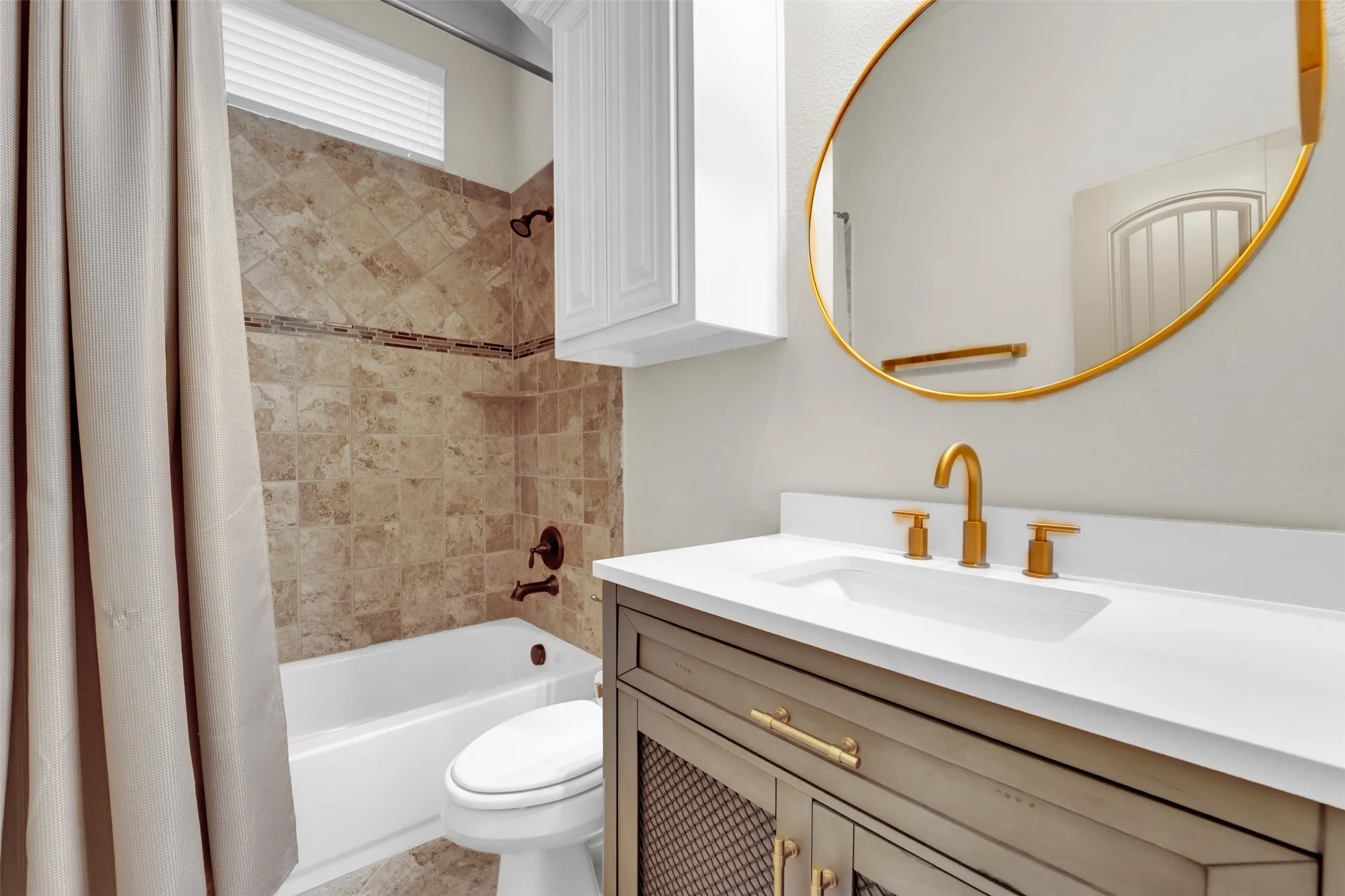 Bathroom featuring a white bathtub, tiled shower surround with accent band, and an overhead transom window