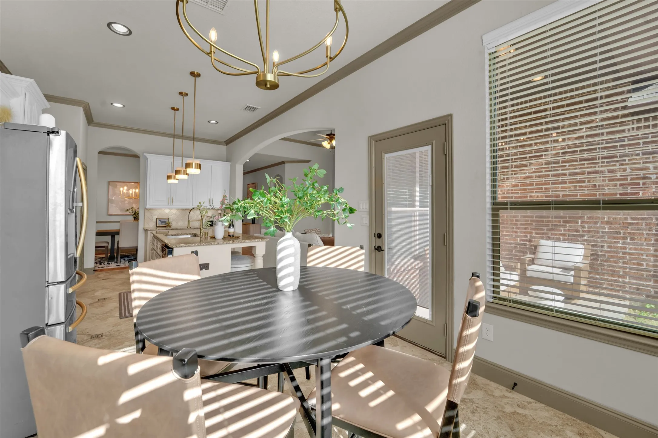 Dining area featuring tile flooring, a brass-finish chandelier, and a glass-paneled exterior door