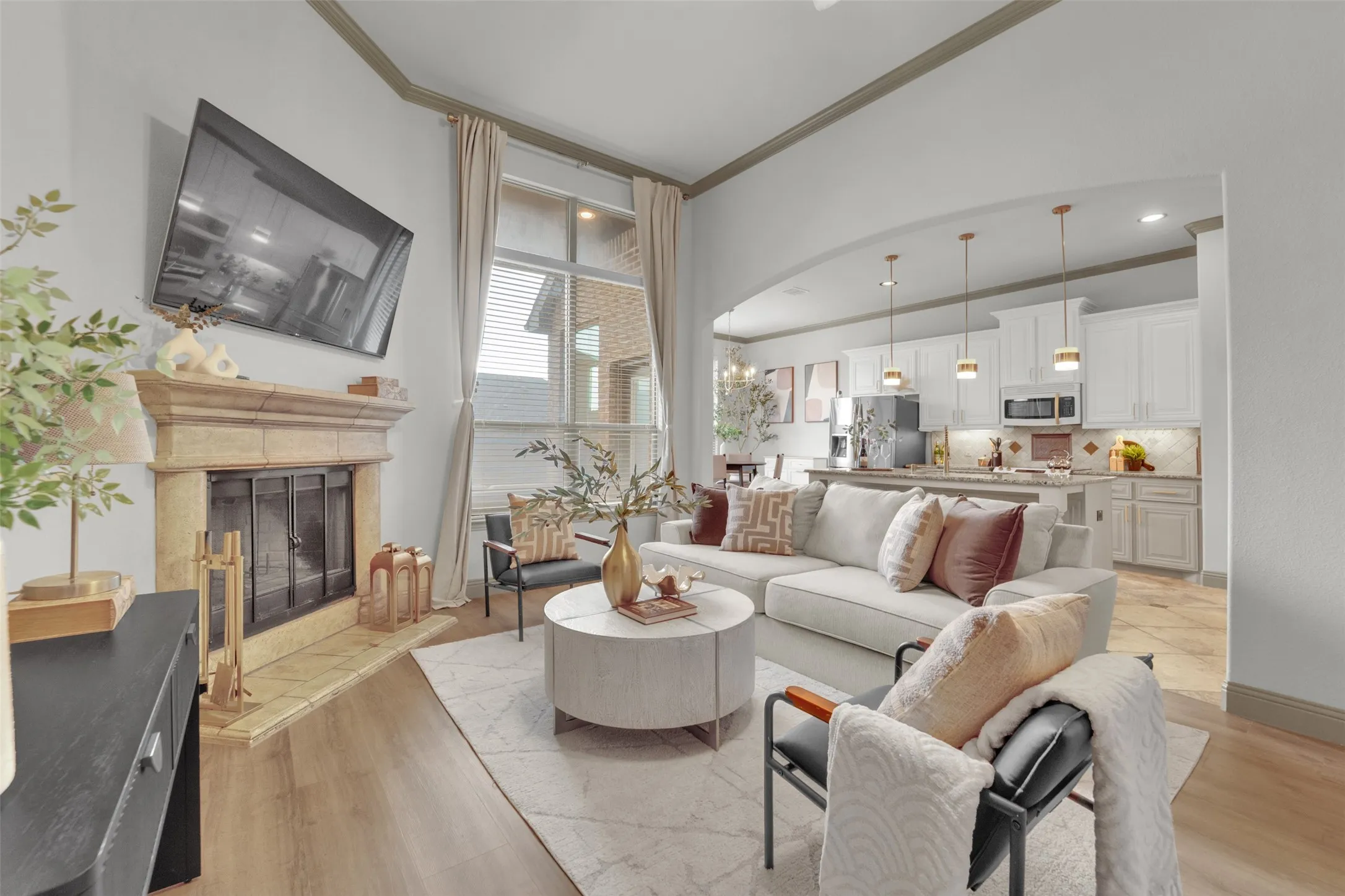 Living area featuring a stone fireplace with a raised hearth, wood-finish flooring, and high ceilings