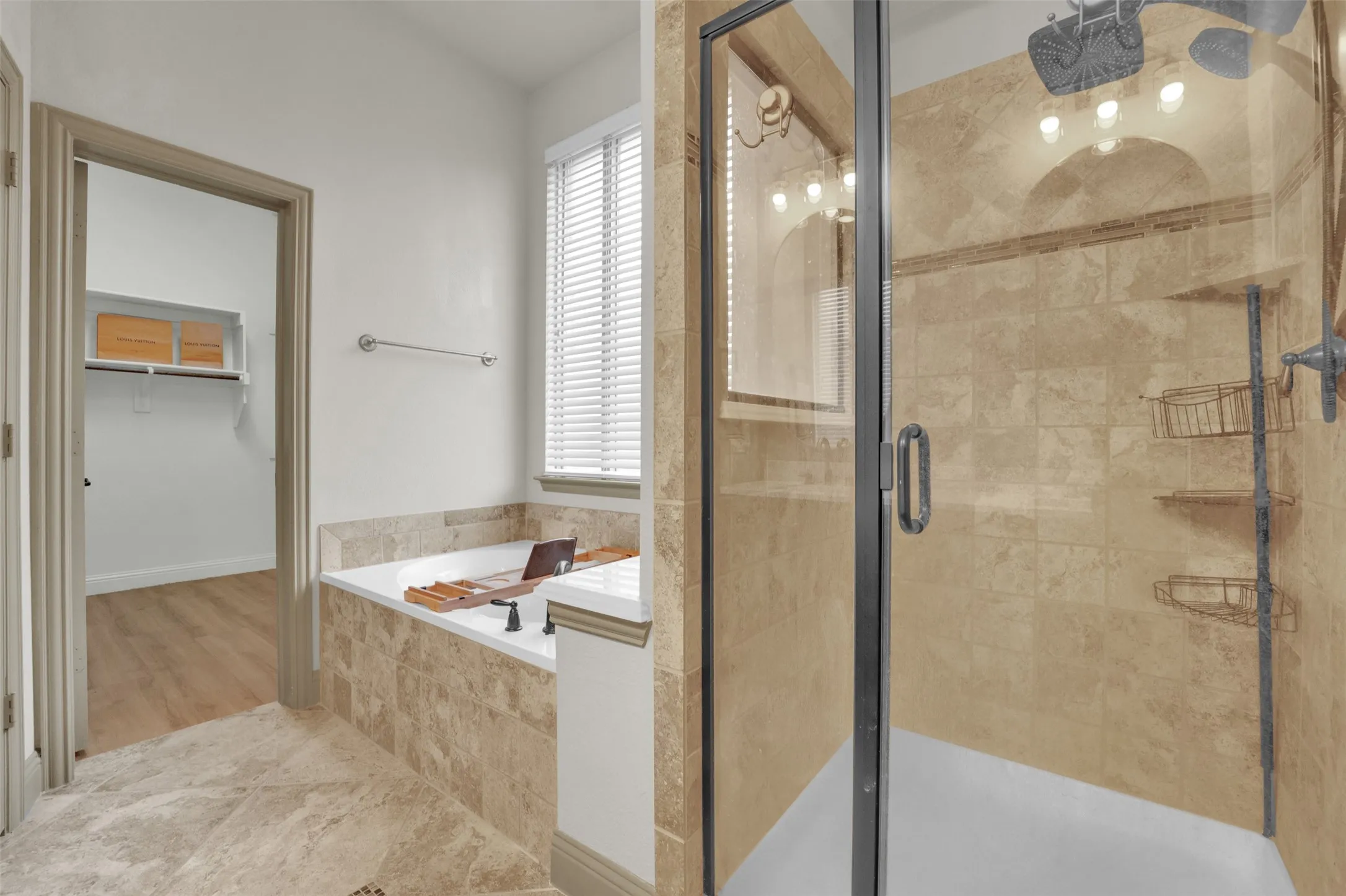 Glass-enclosed shower with tiled walls and a built-in tub with coordinating tile surround
