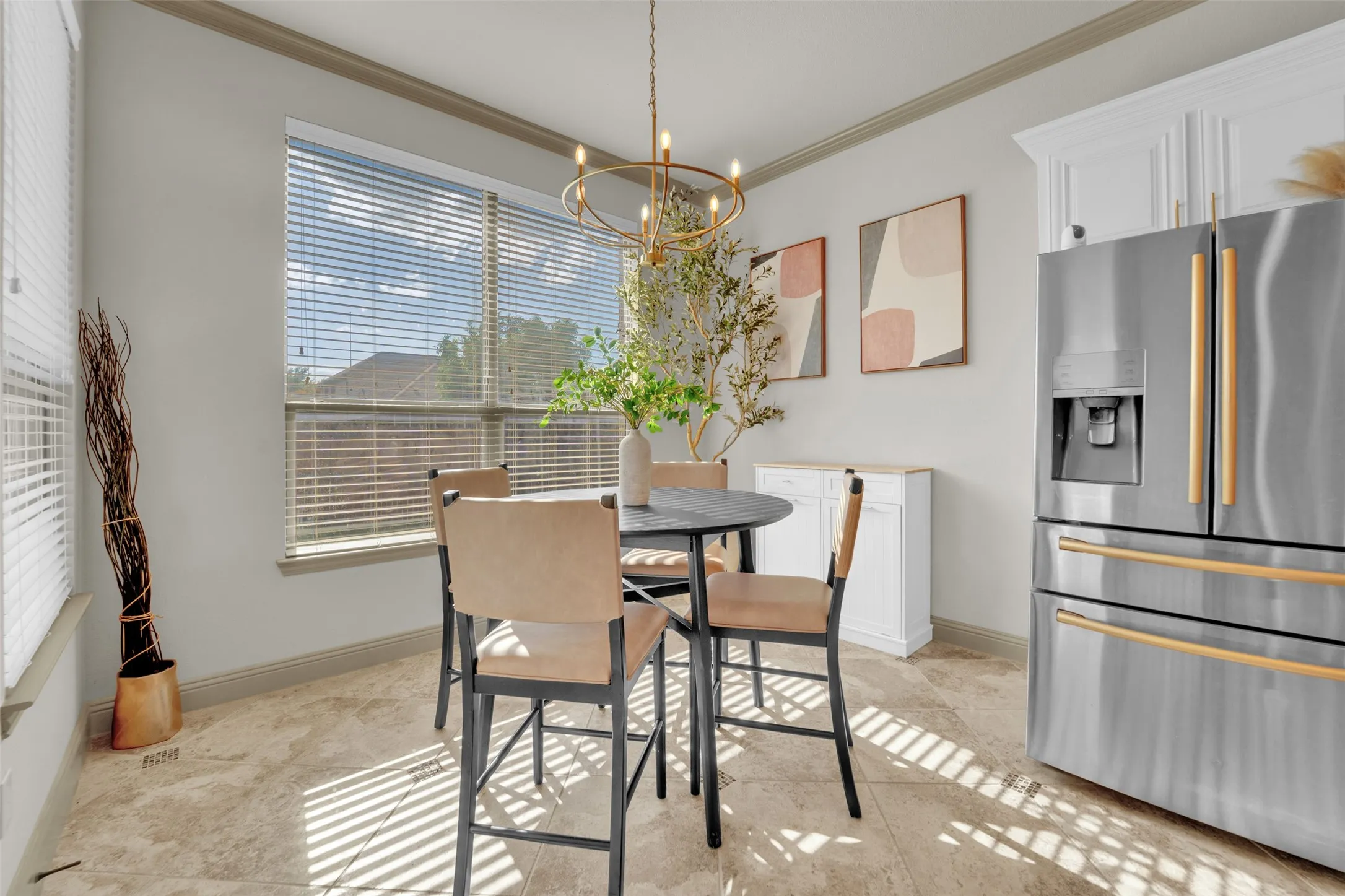 Dining area featuring a contemporary brass chandelier, large windows with blinds, built-in cabinetry, and tile flooring