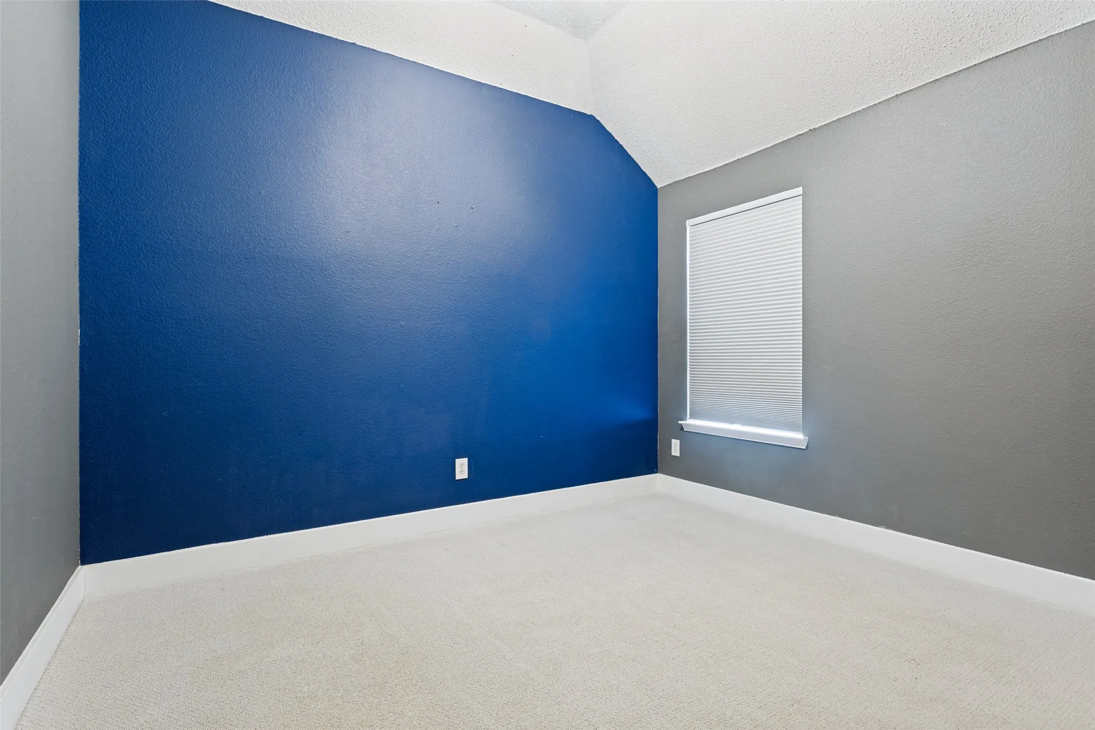 Vaulted ceilings with a prominent blue accent wall and neutral gray walls