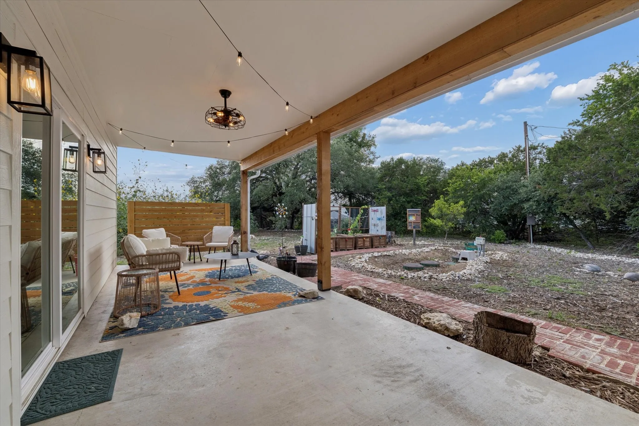 Expansive covered patio featuring a ceiling fan, string lighting, and direct access to the outdoor space
