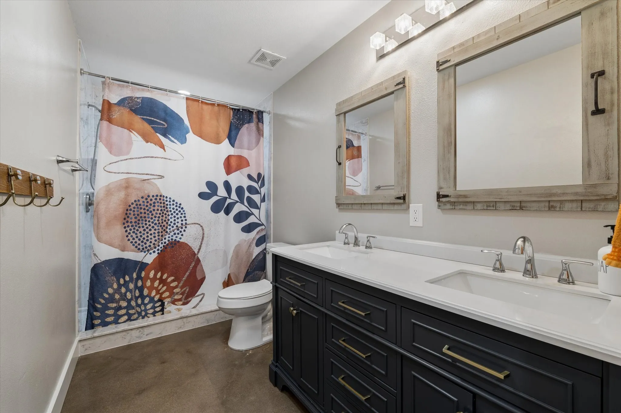 Double vanity with white countertop, chrome fixtures, and dark wood cabinetry