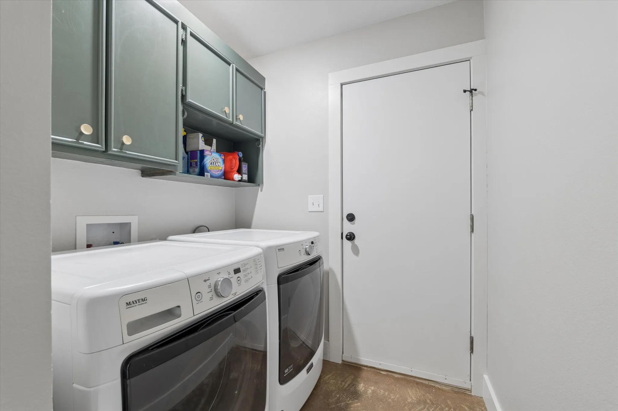 Laundry area featuring upper cabinetry with gold-tone hardware and an open shelf