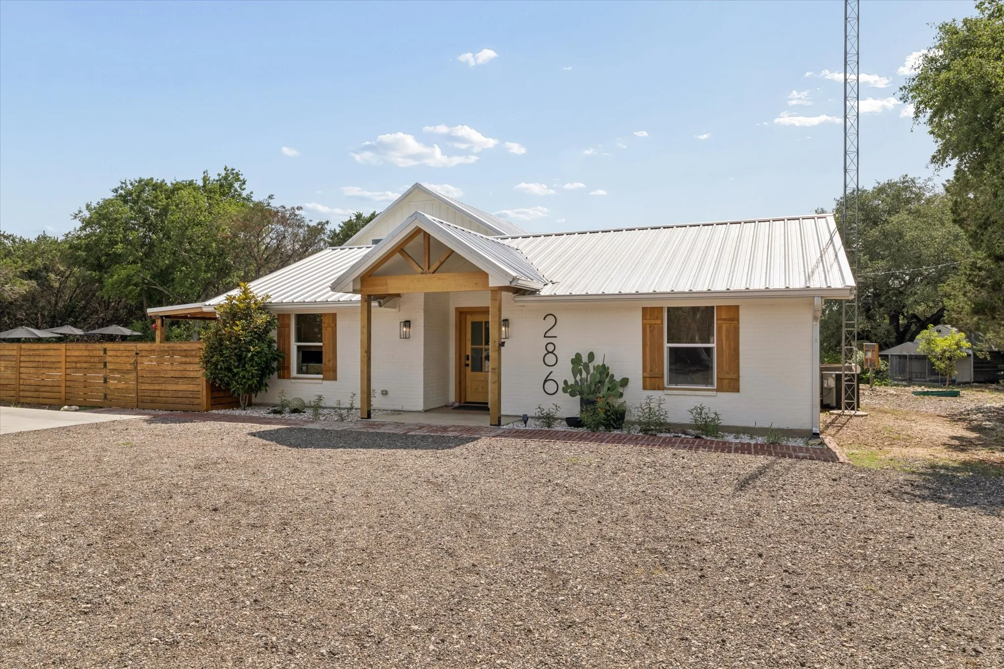 White stucco exterior with a prominent covered entry featuring natural wood accents