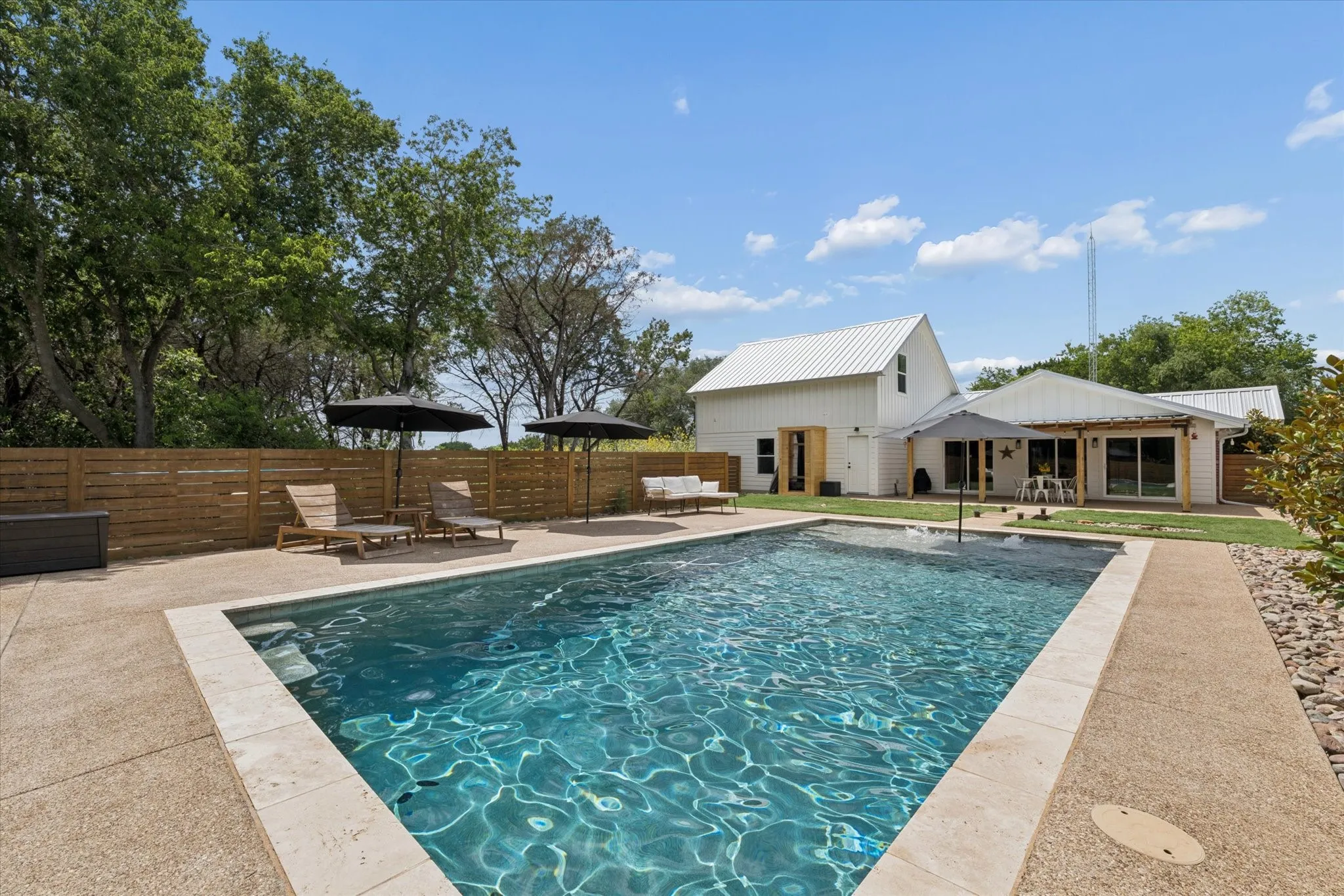 Custom-shaped swimming pool with stone coping and an expansive concrete surround