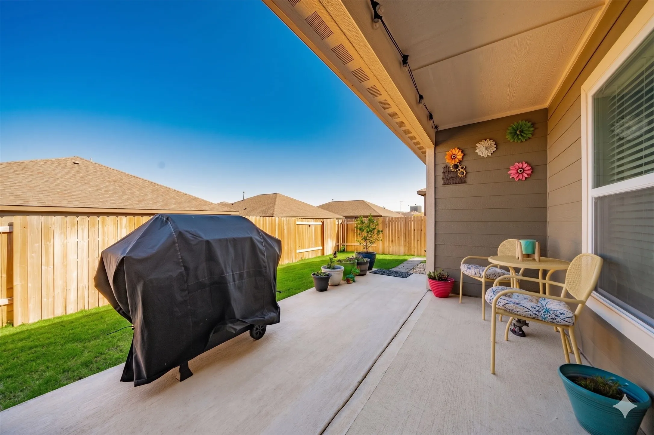 Covered patio featuring track lighting, a concrete slab, and direct access to the backyard