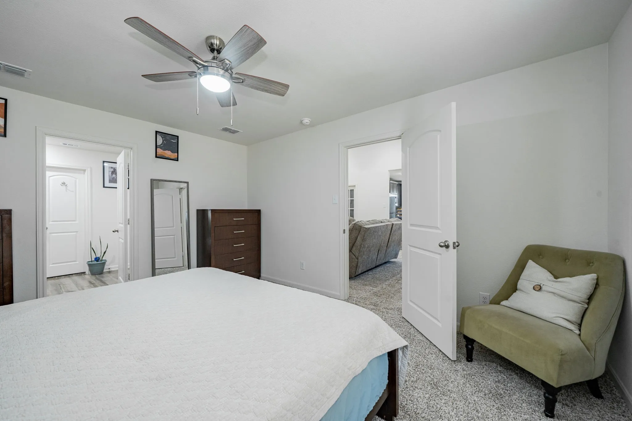 Bedroom featuring neutral carpet flooring, white walls, and a ceiling fan with integrated lighting