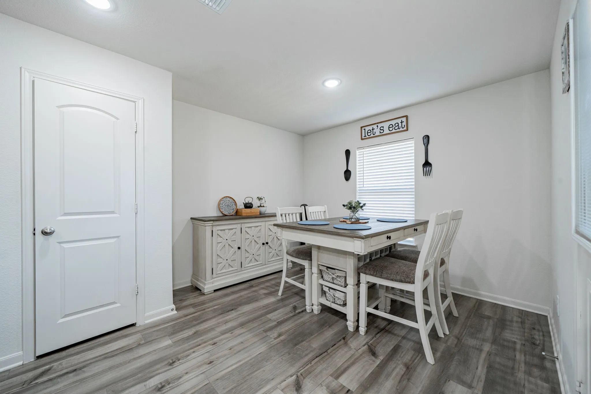 Dining space with wood-finish flooring, white walls, and recessed lighting