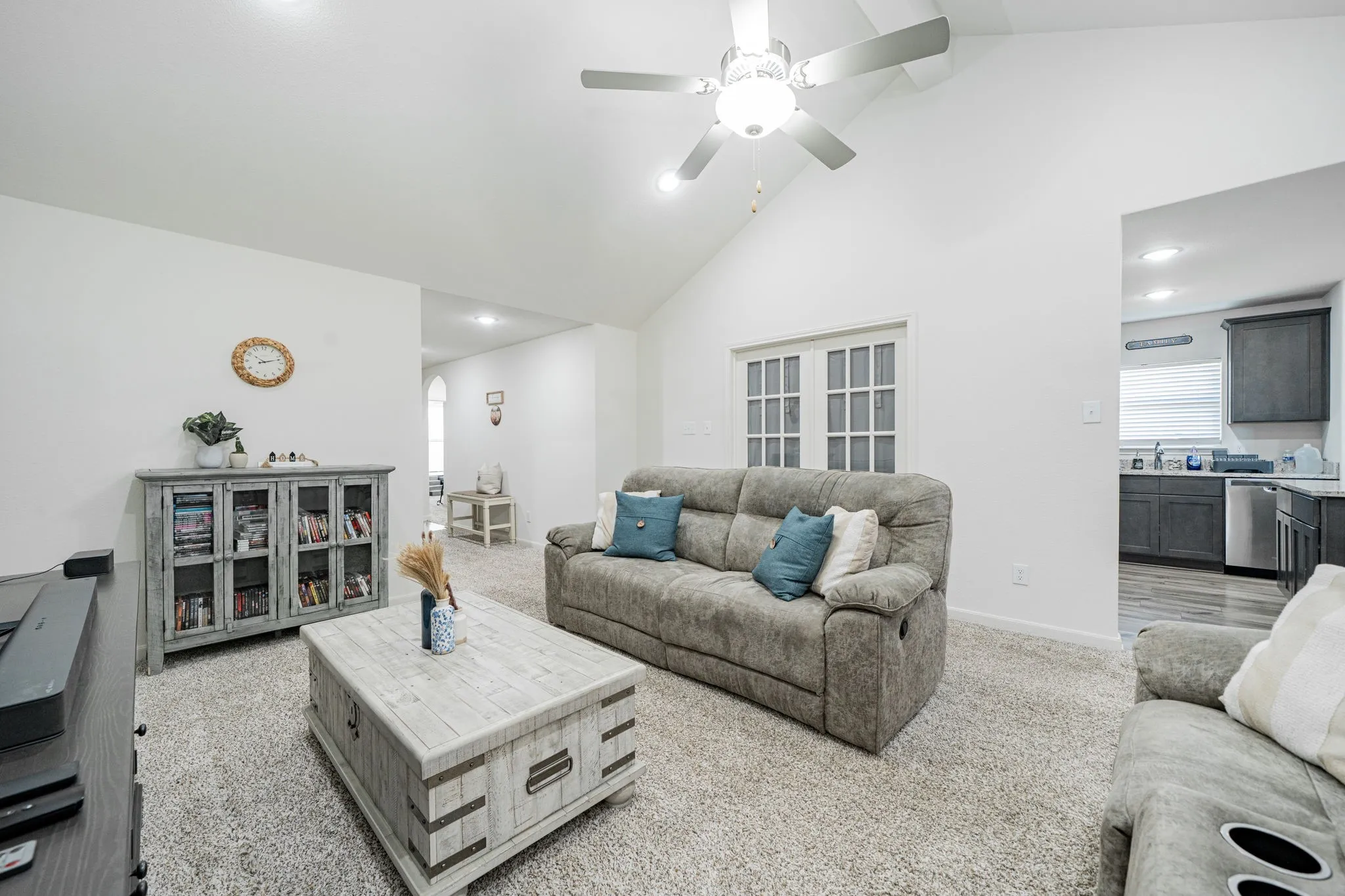 Vaulted ceiling living area featuring recessed lighting and a ceiling fan with light fixture