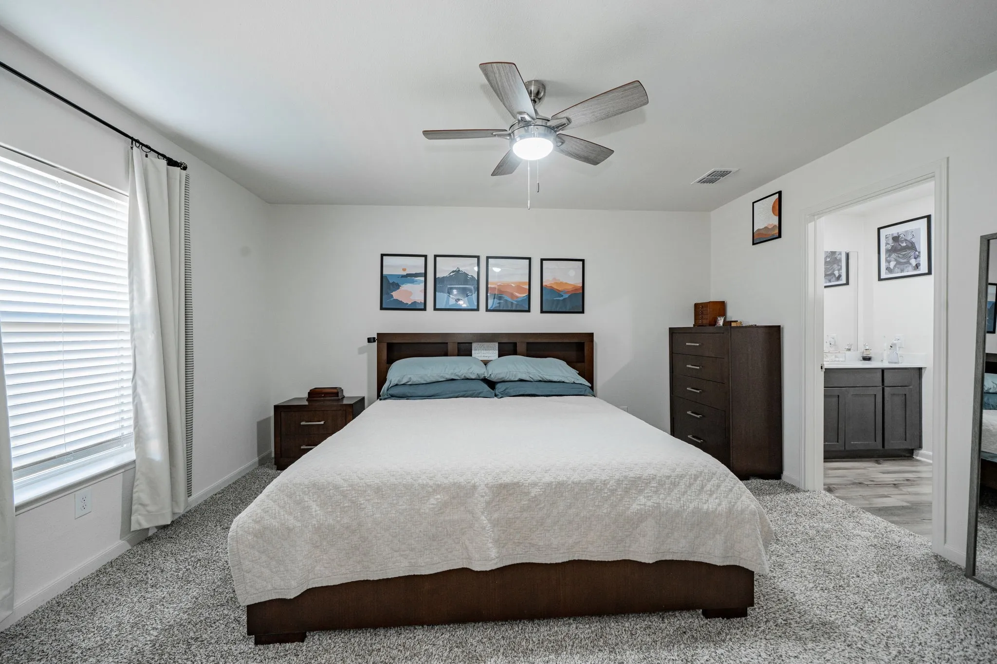 Carpeted bedroom with a ceiling fan