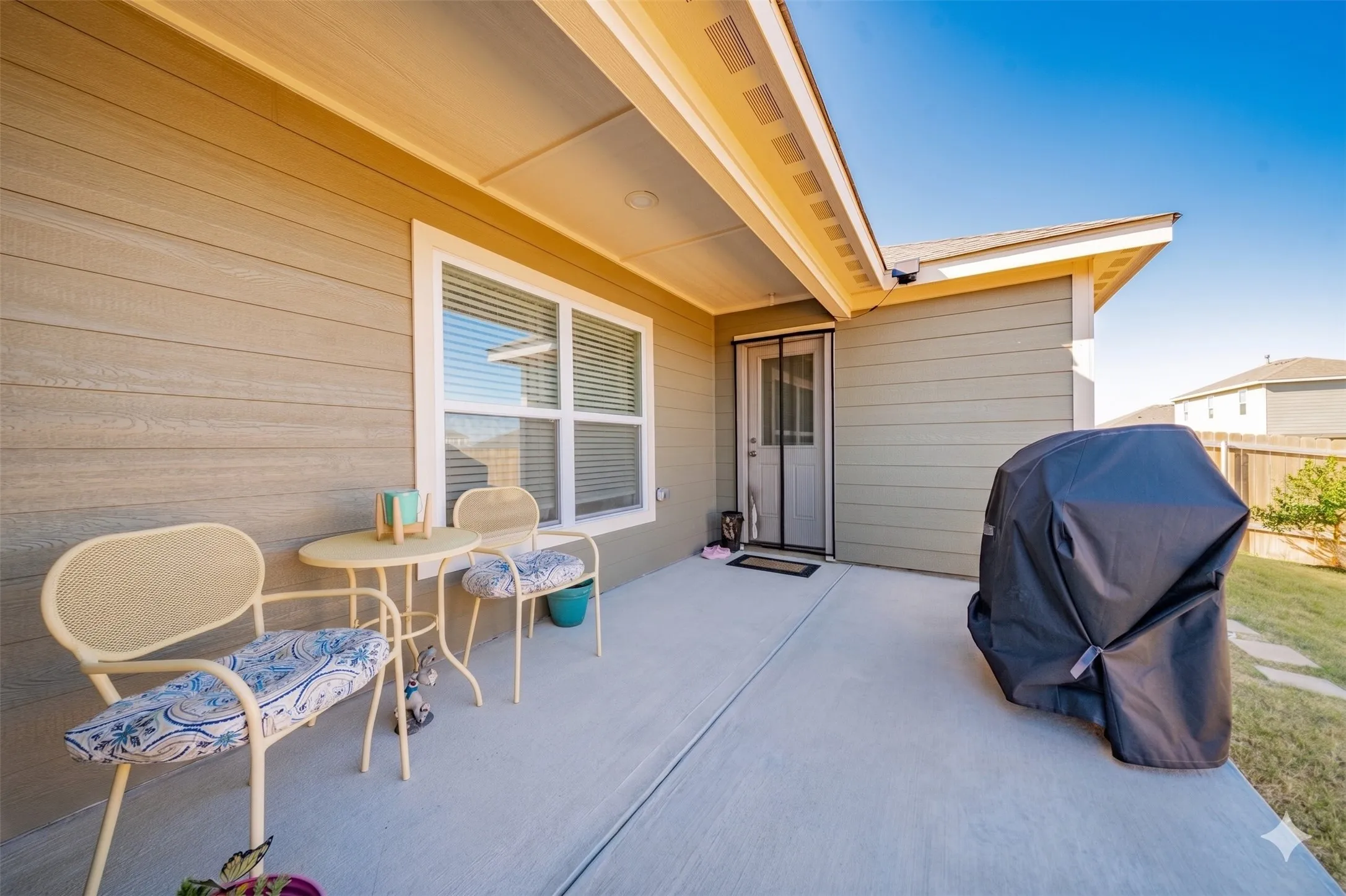 Expansive covered patio featuring a concrete surface, tan siding, recessed lighting, and direct exterior door access