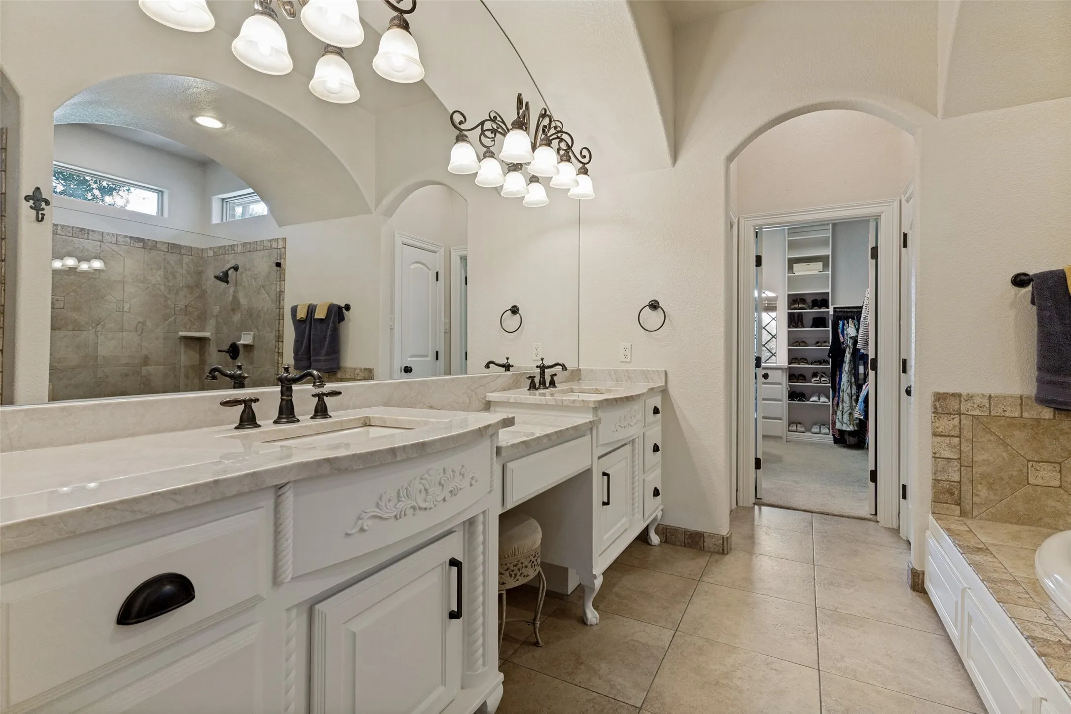 Dual vanity with stone countertops and bronze fixtures