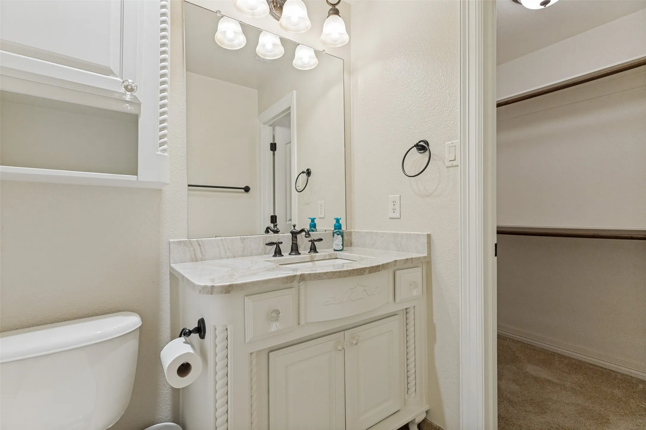 Bathroom vanity with a light-toned countertop, a built-in sink, and dark-finished fixtures