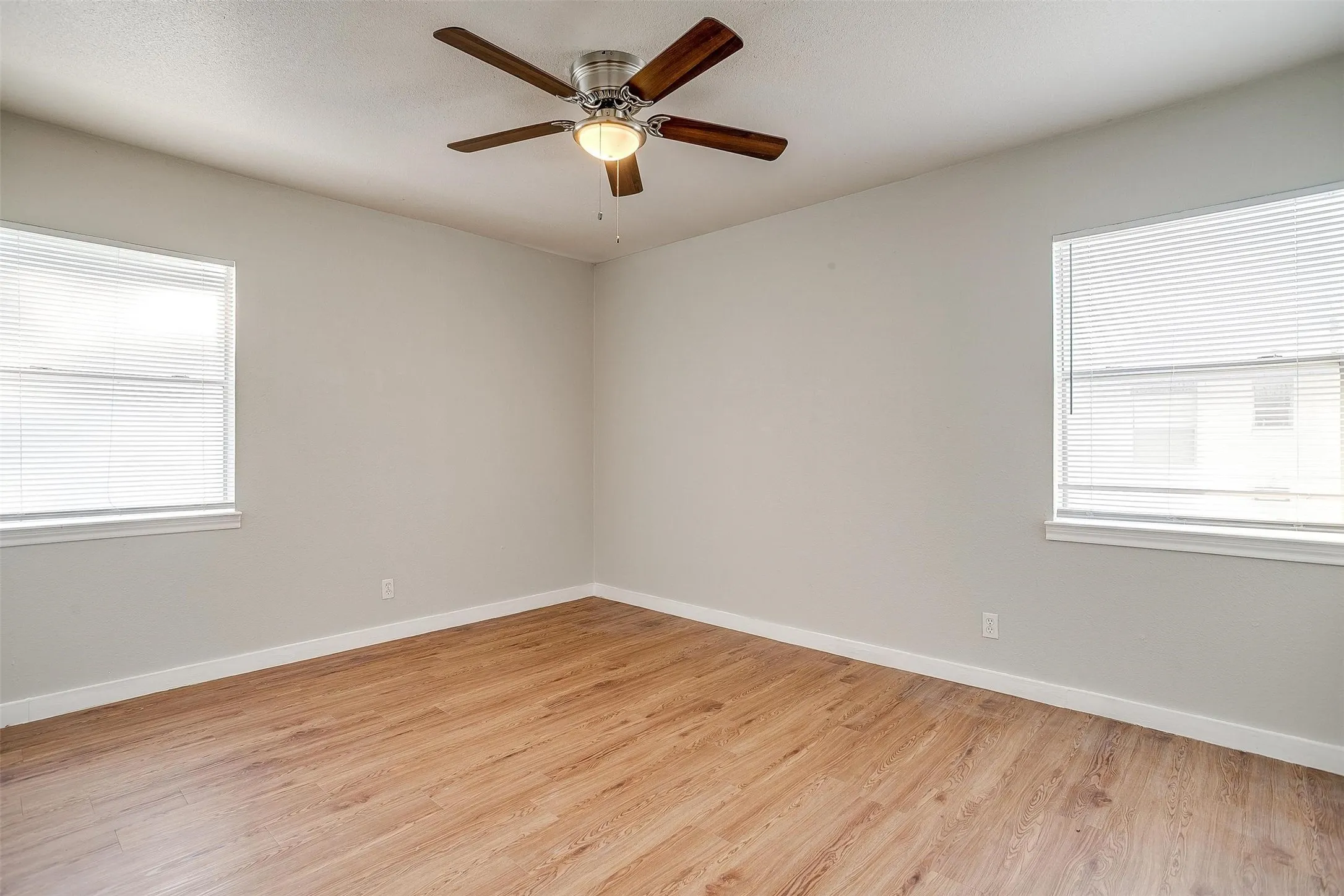 Bright room featuring wood-finish flooring and light-toned walls
