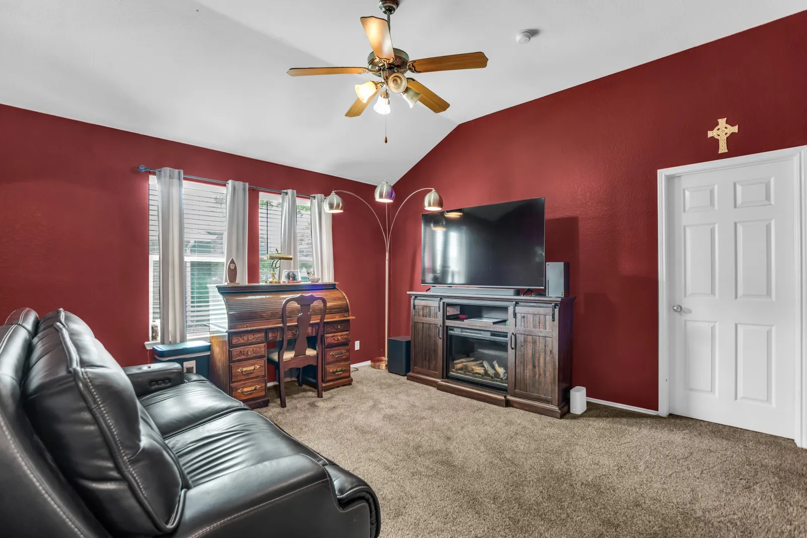 Carpeted room with a vaulted ceiling and a ceiling fan