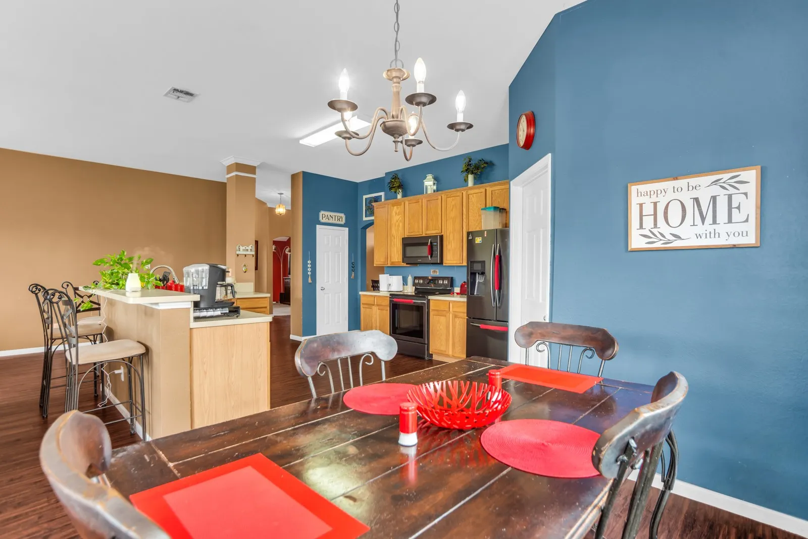 Spacious dining area featuring wood-finish flooring and a decorative chandelier