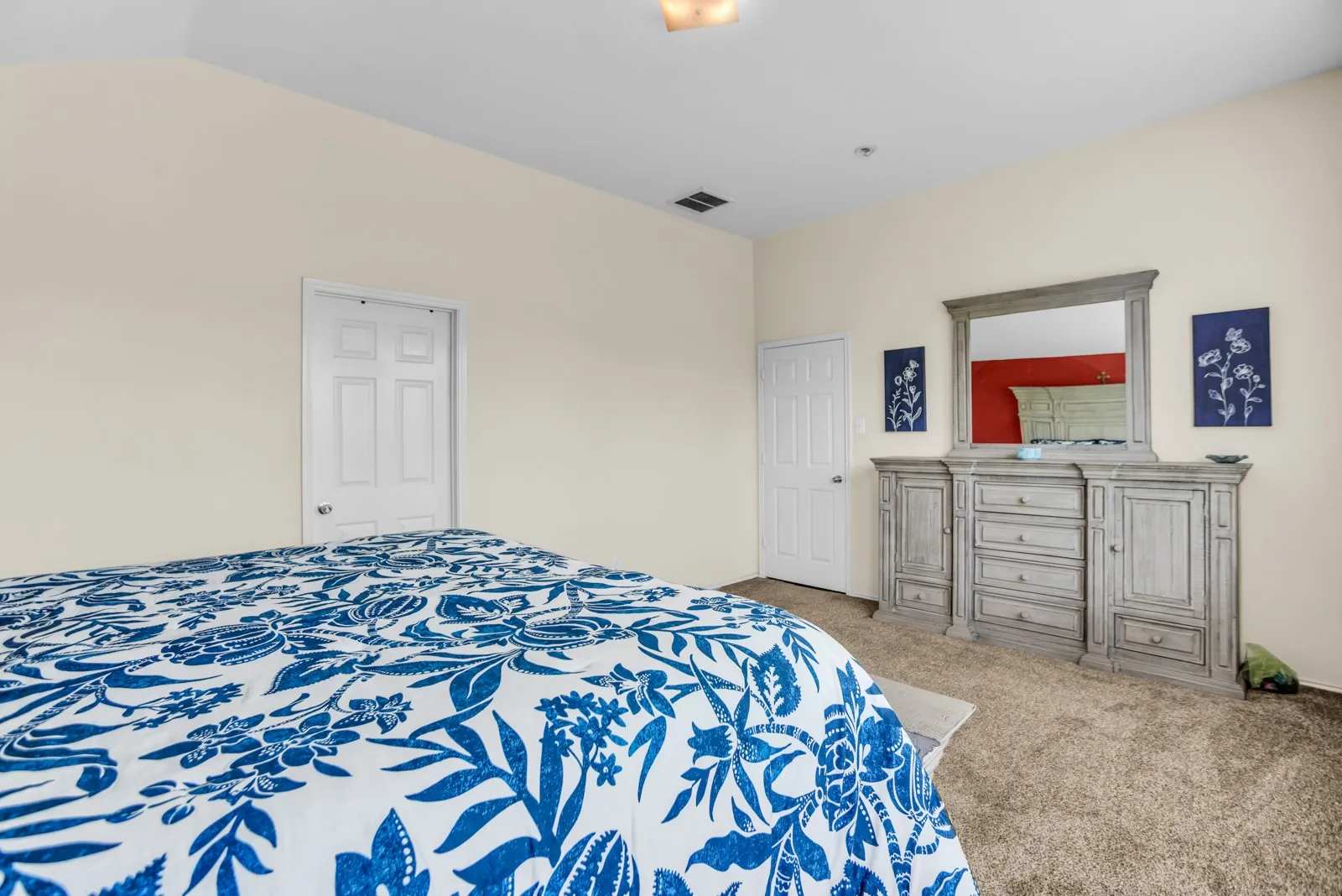 Spacious room featuring neutral-toned walls, plush carpet flooring, and white paneled doors