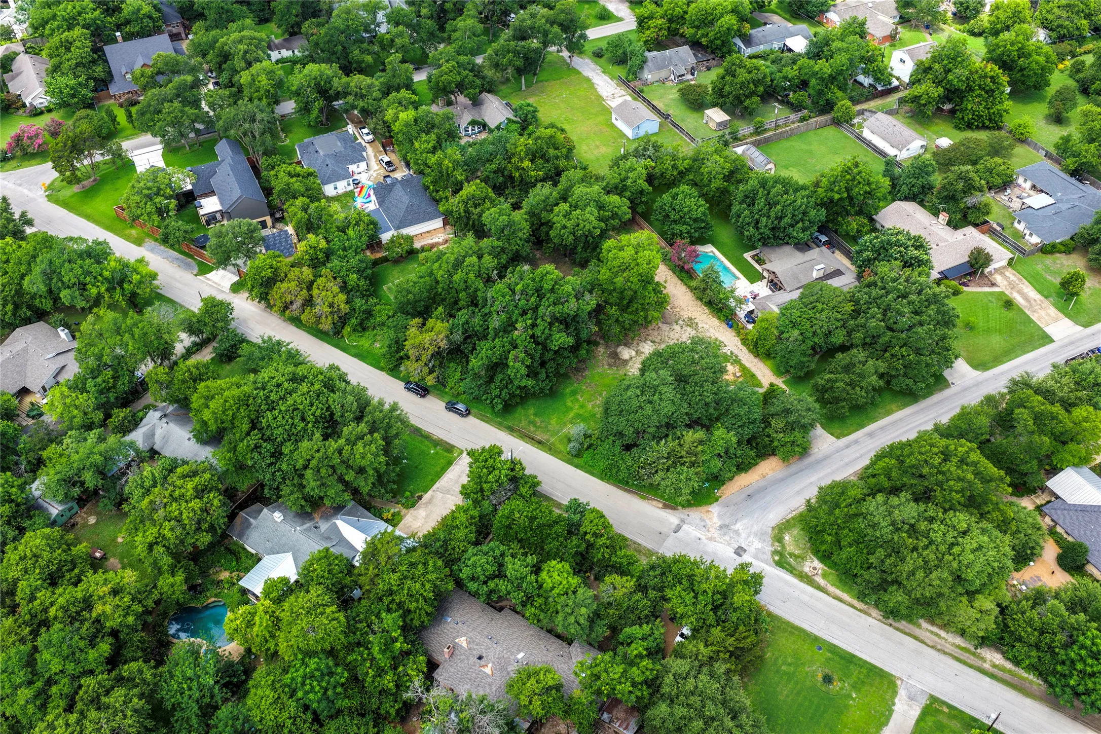 Aerial perspective showcasing a residential neighborhood with extensive mature tree coverage