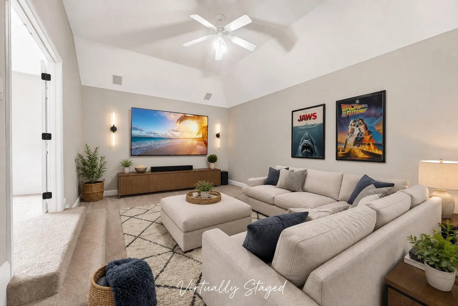Virtually Staged. Vaulted ceiling, wall-mounted sconces, recessed ceiling speakers, wood-finish media console, and carpeted flooring