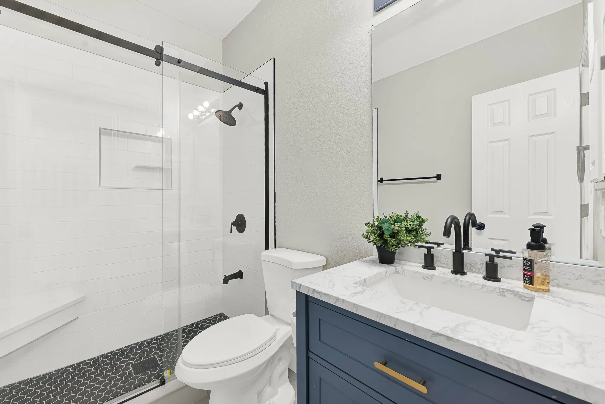 Bathroom featuring a walk-in shower with clear glass enclosure and black hardware