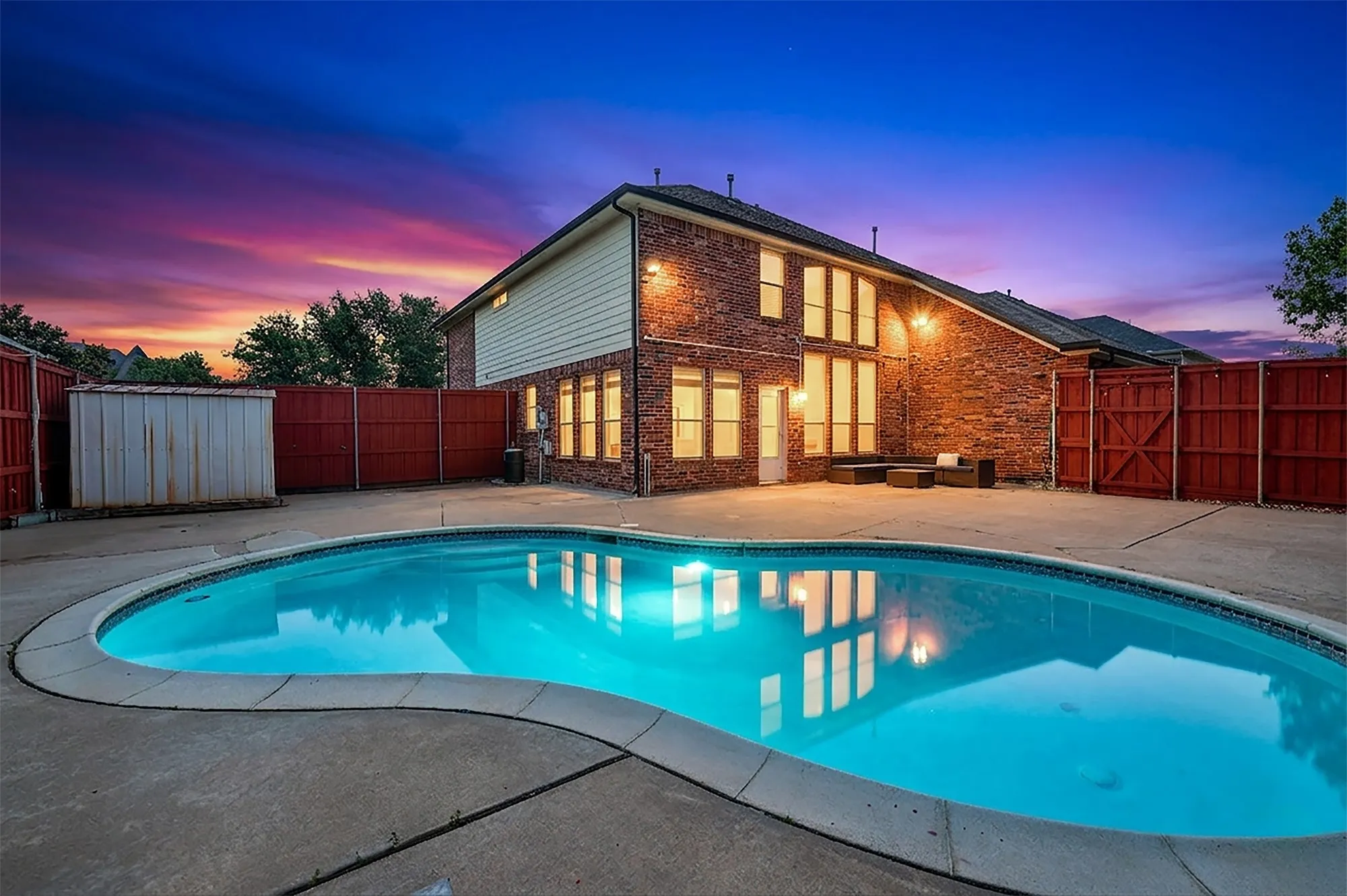 Backyard featuring an in-ground swimming pool with concrete surround