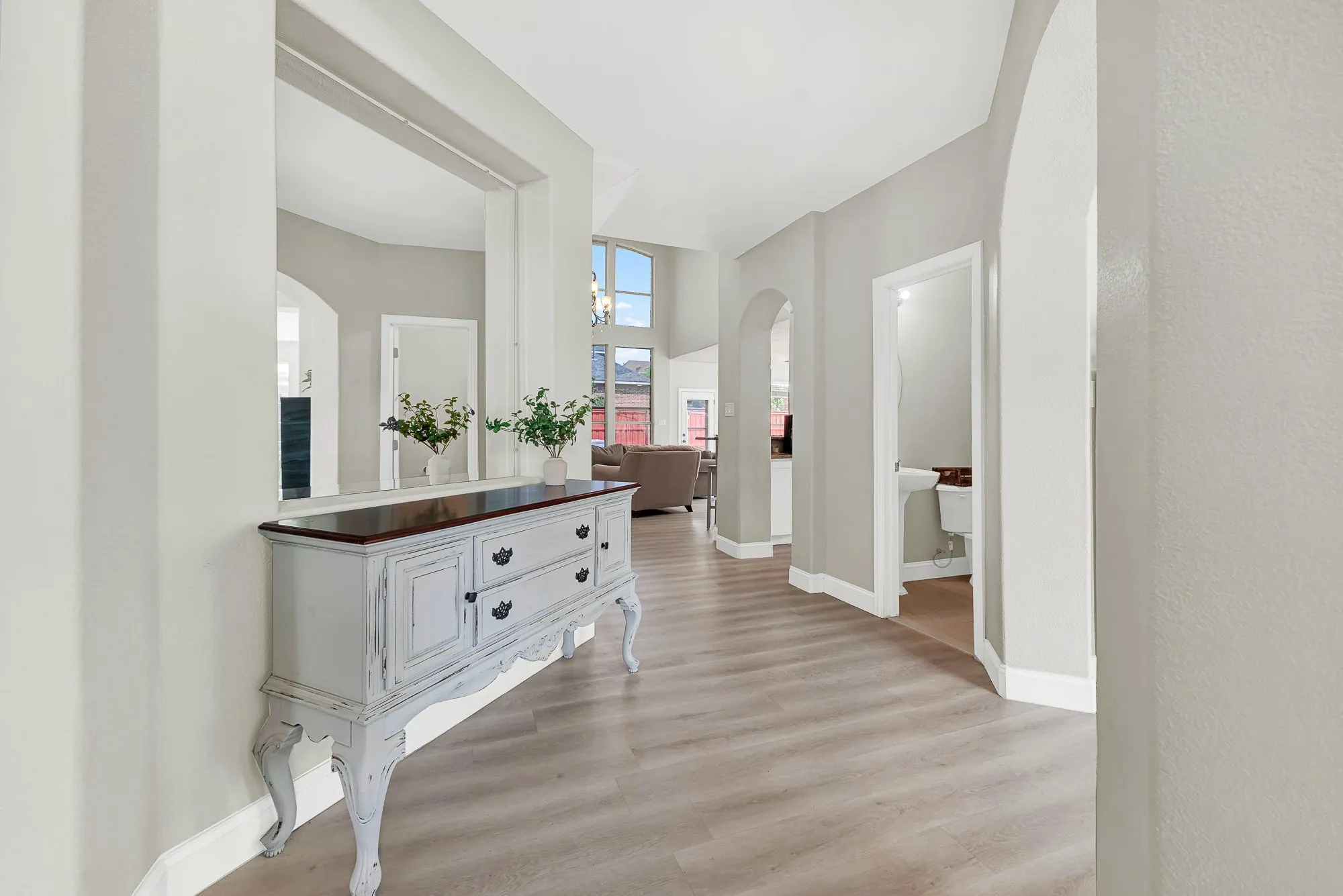 Hallway featuring wood-finish flooring, light gray walls, and white baseboards