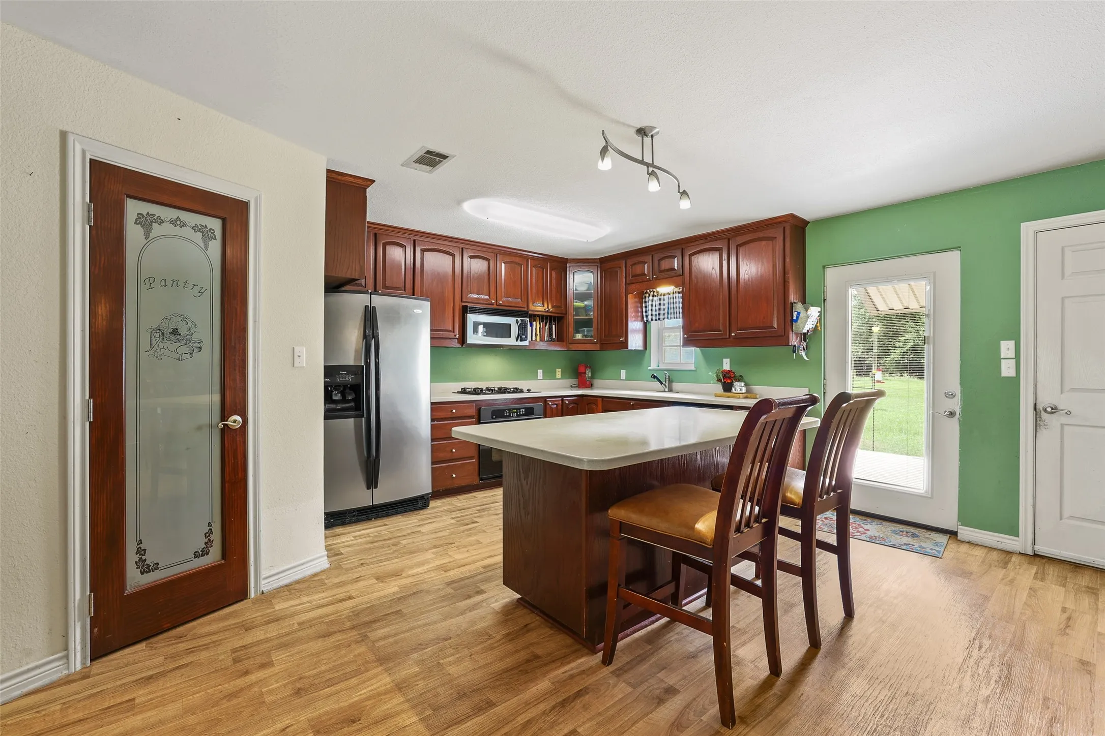 Kitchen has a large island and walk-in pantry