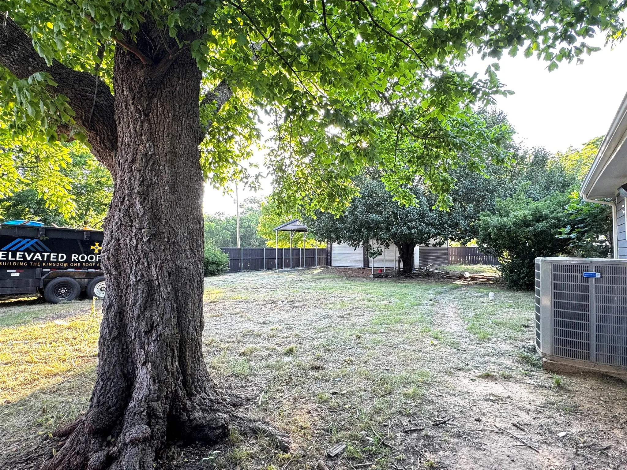 Tall privacy wood fence surrounding the entire 0.33-acre lot with field views.