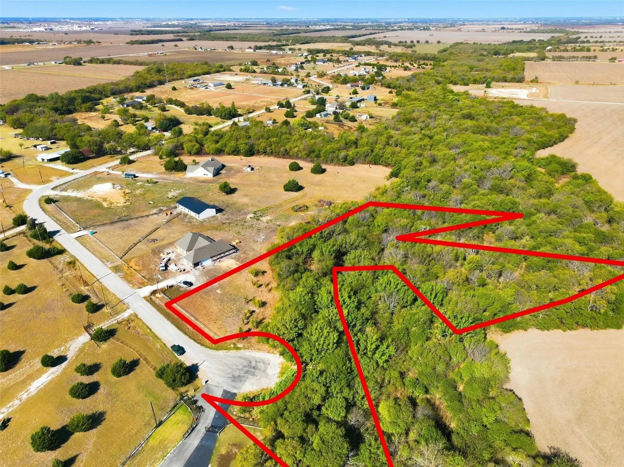 Expansive undeveloped lot featuring mature tree coverage, a cul-de-sac frontage, and a partially cleared area